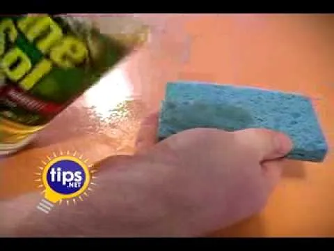 A hand dusting on a DIY cleaning solution on a greasy white piece of fabric.