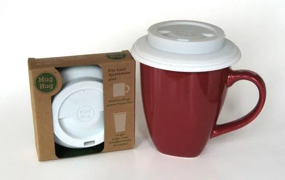 Red ceramic coffee mug with a white lid, next to its packaging.