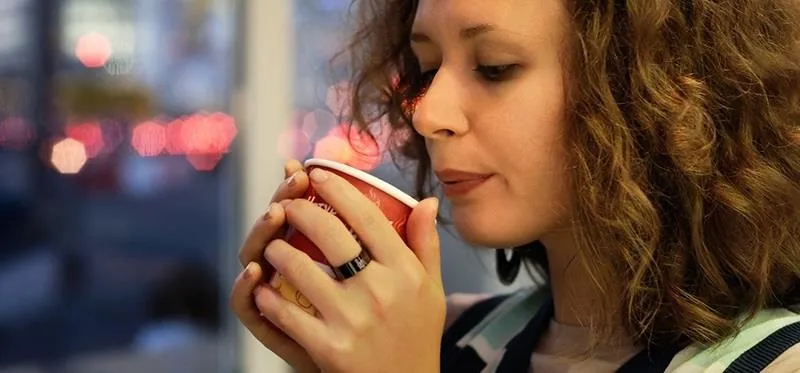 Young woman savoring a warm beverage.