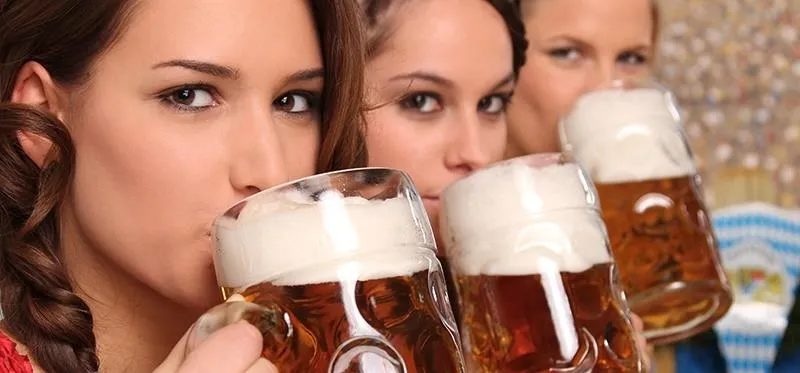 Three women enjoying beer in a social setting.