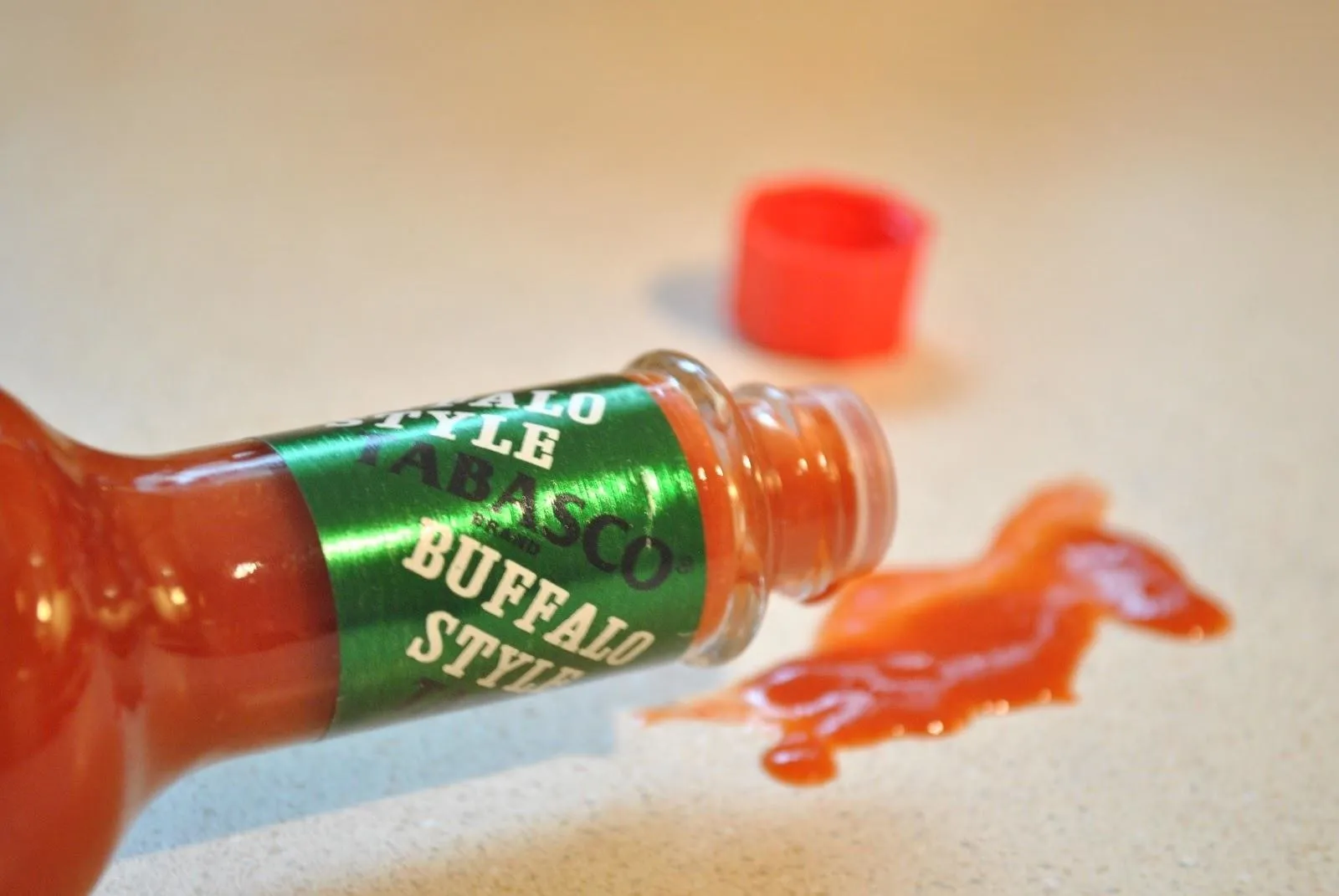 Tabasco buffalo sauce bottle with spilled sauce.