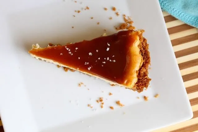 Caramel cheesecake slice on a white plate.