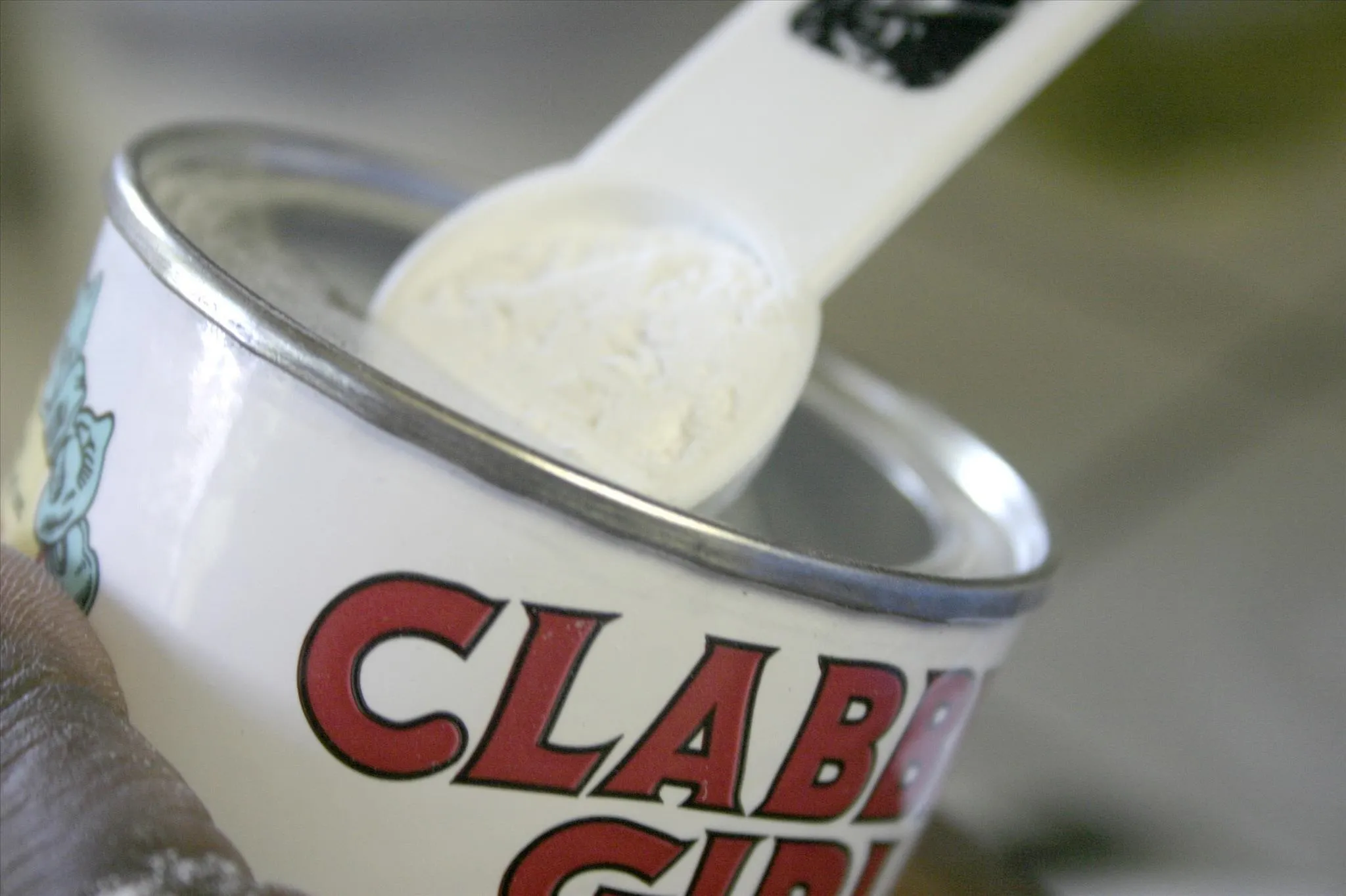 Clabber Girl baking powder with measuring spoon inside the can.