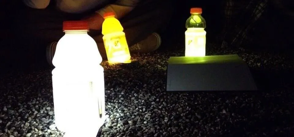 Illuminated sports drink bottles in a dark setting.