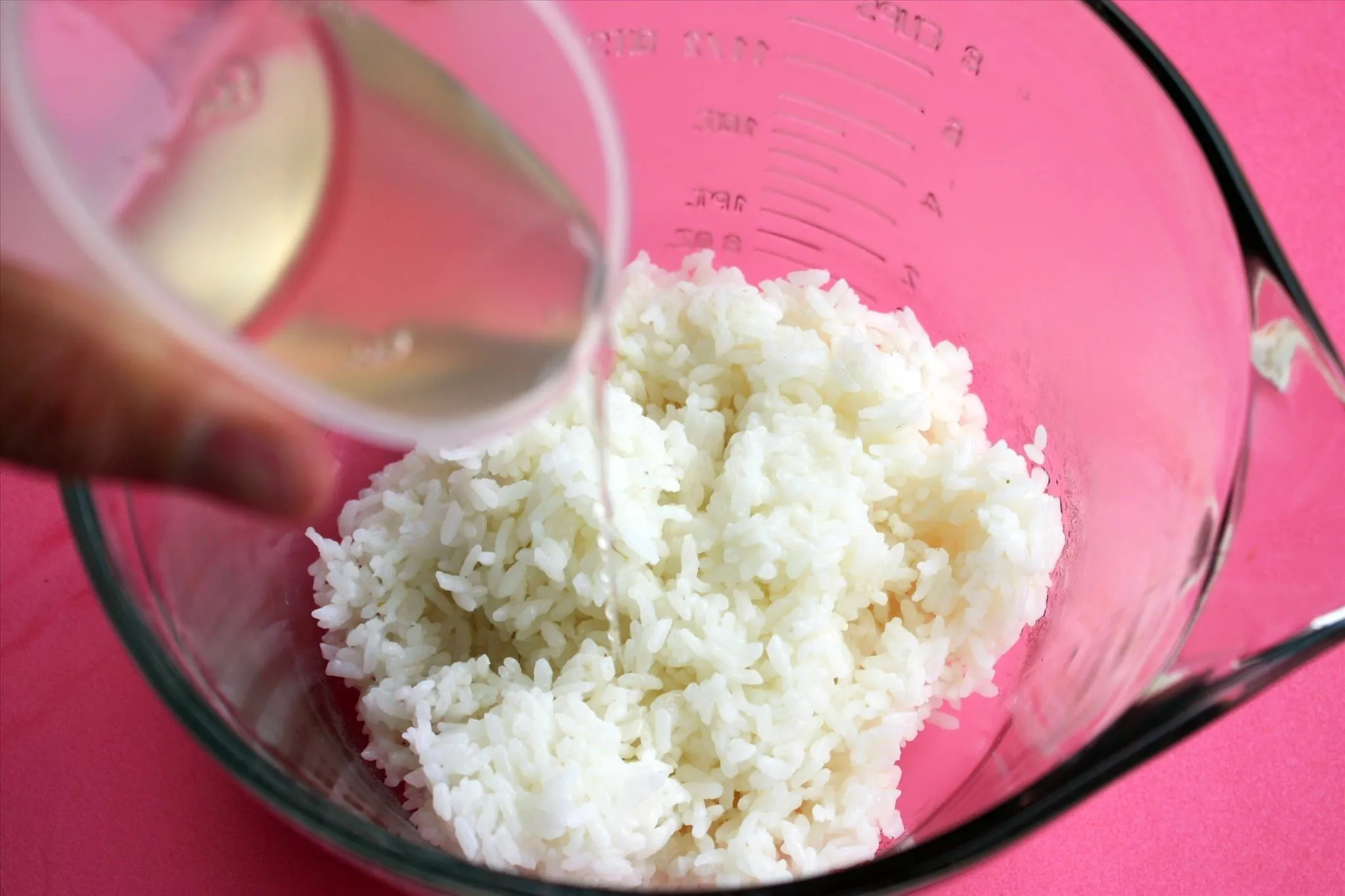 Pouring liquid into a bowl of rice.