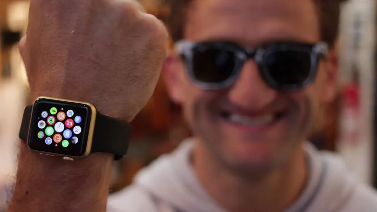 Man wearing sunglasses showing an Apple Watch on his wrist.