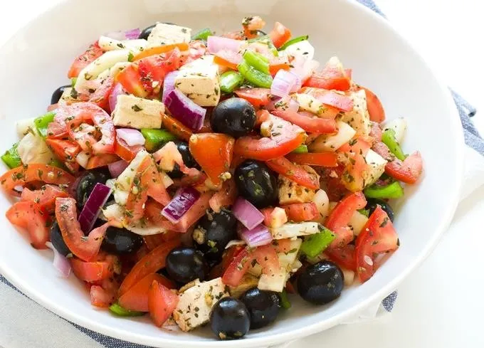 Mediterranean salad with tomatoes, cucumbers, olives, and feta cheese.