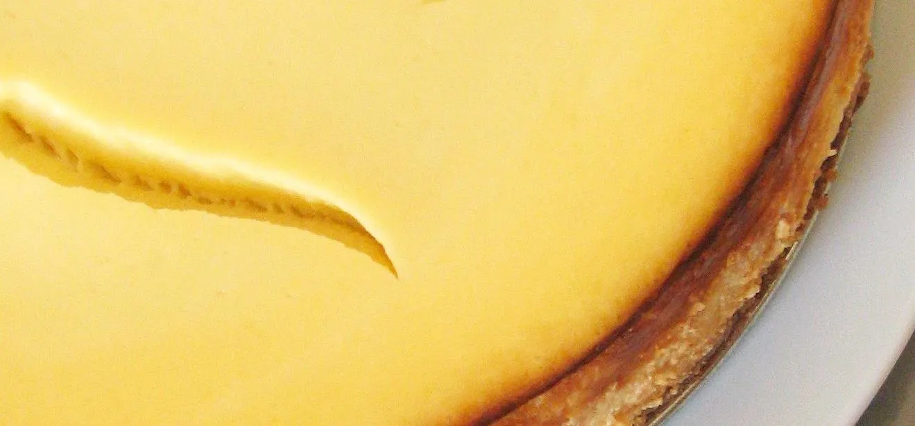 Cheesecake with a smooth yellow top.