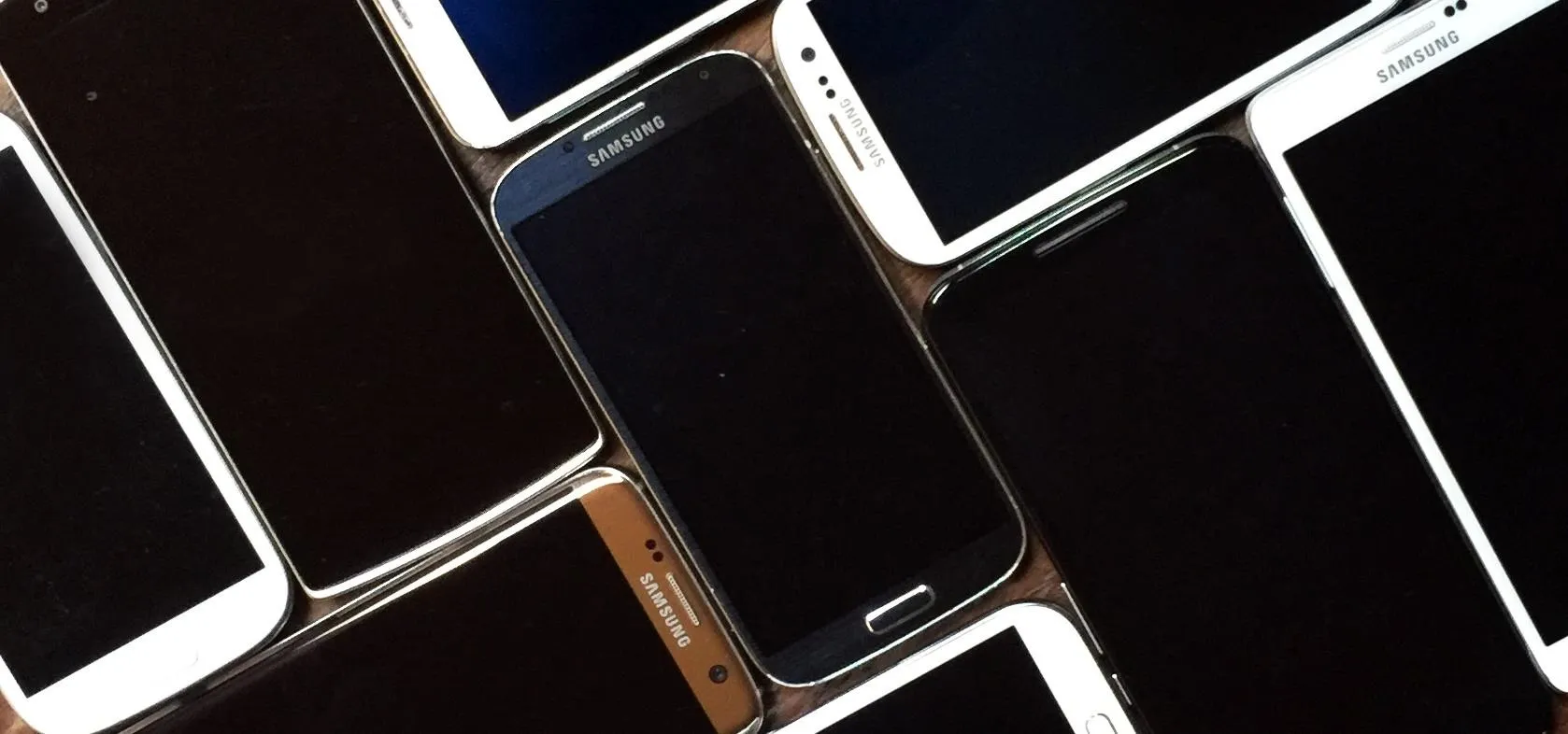 Smartphones arranged in a cluster with black screens.
