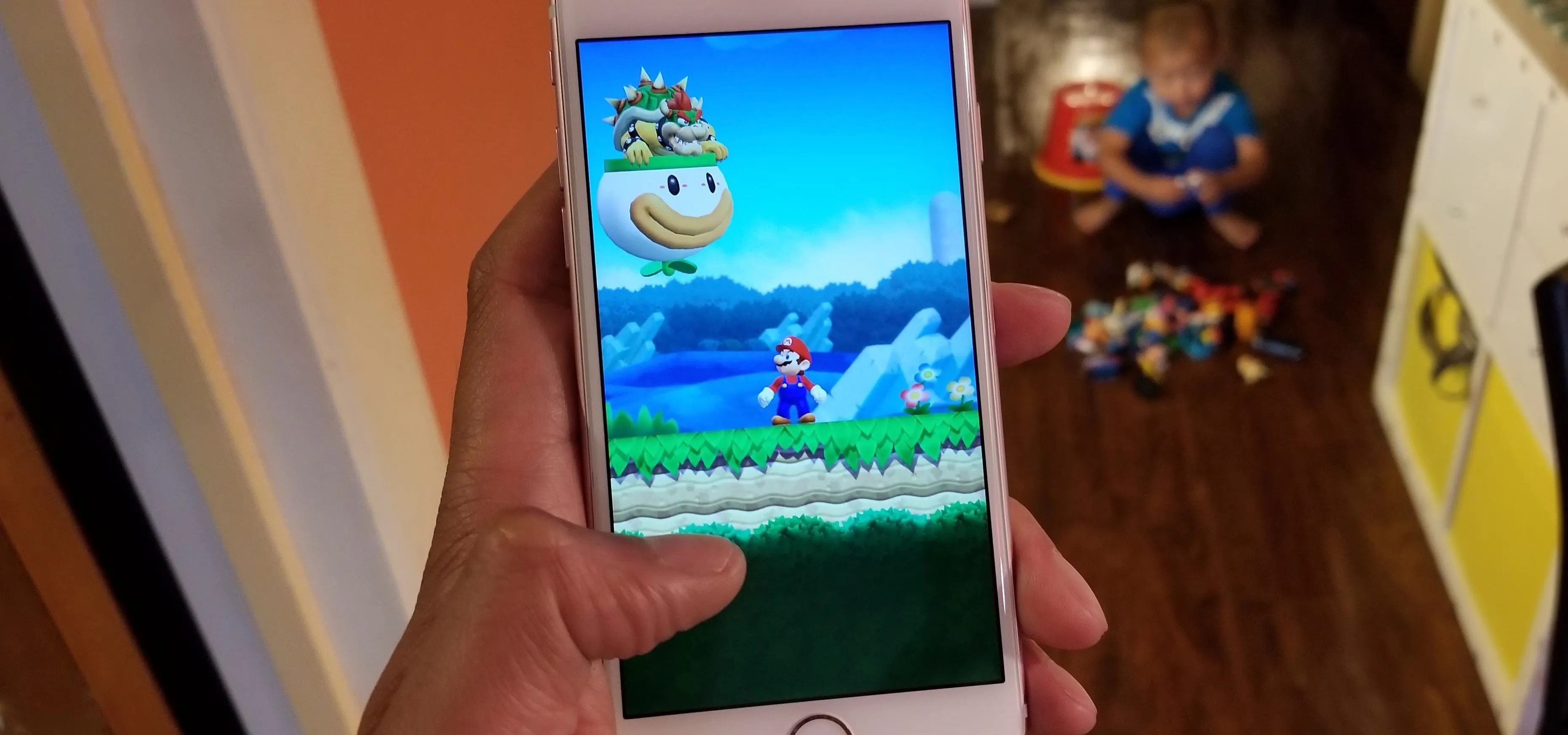 A person playing a Mario video game on a smartphone.