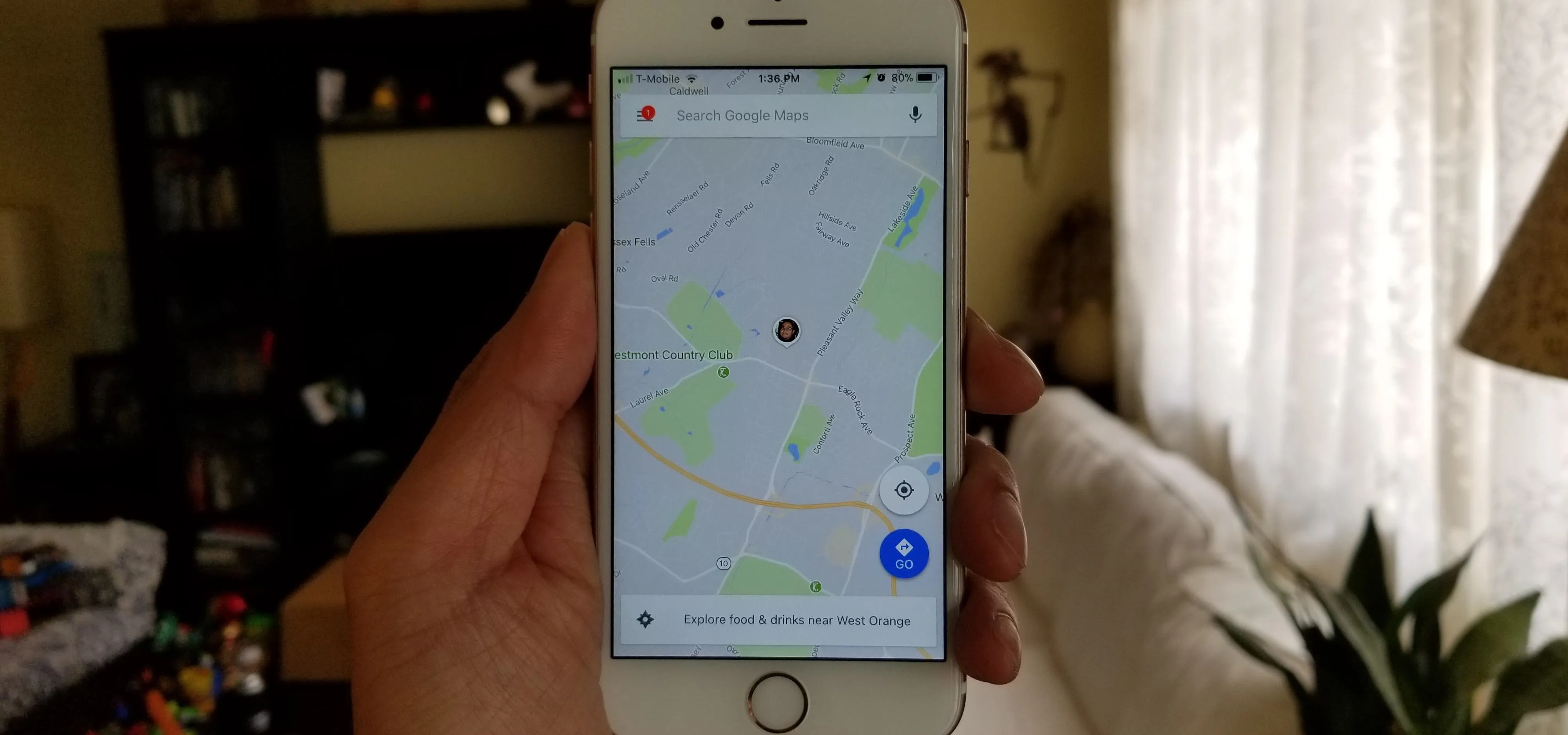 Hand holding a smartphone displaying a map application.