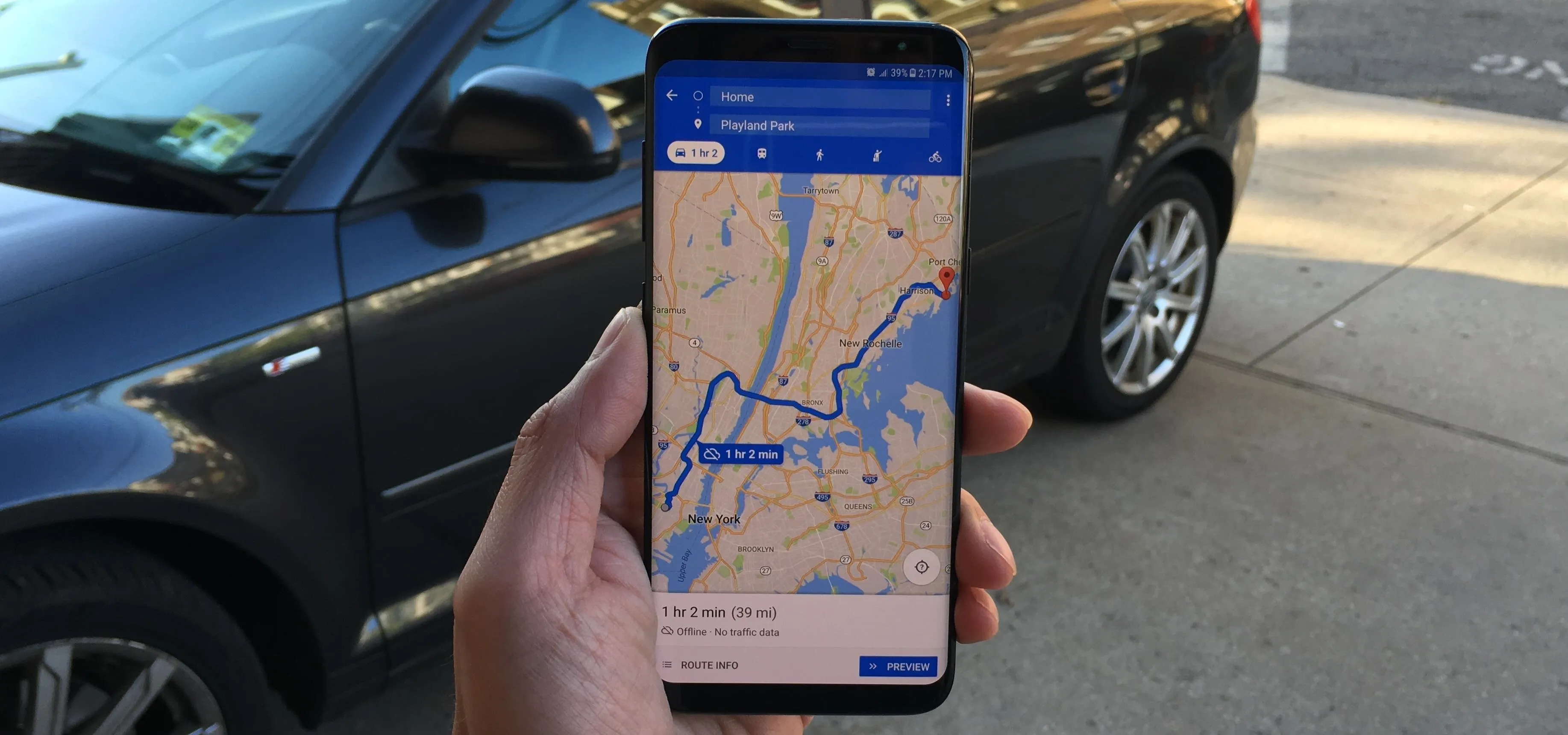 A hand holding a smartphone displaying a map and directions.