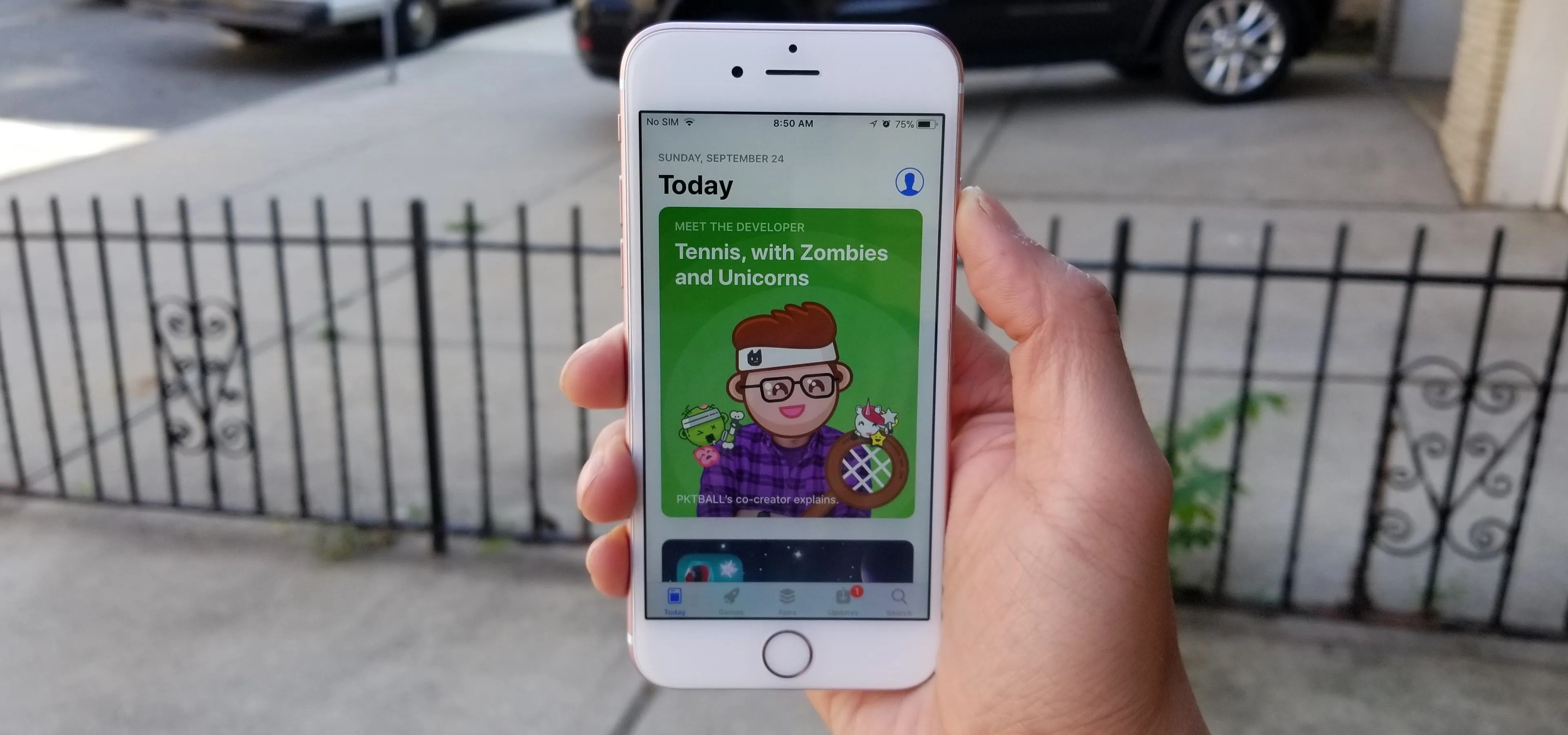 A person holding a smartphone displaying a colorful cartoon character on the screen.