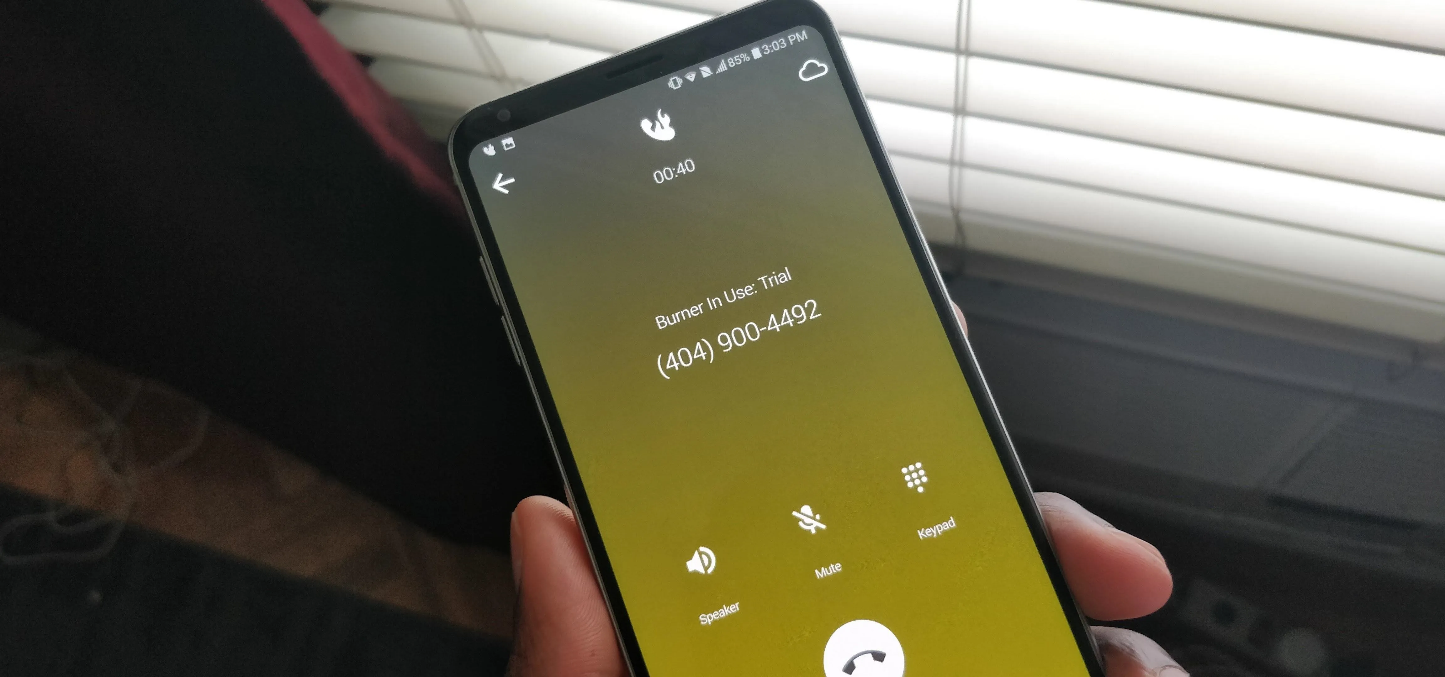 A person holding a smartphone displaying a call interface.