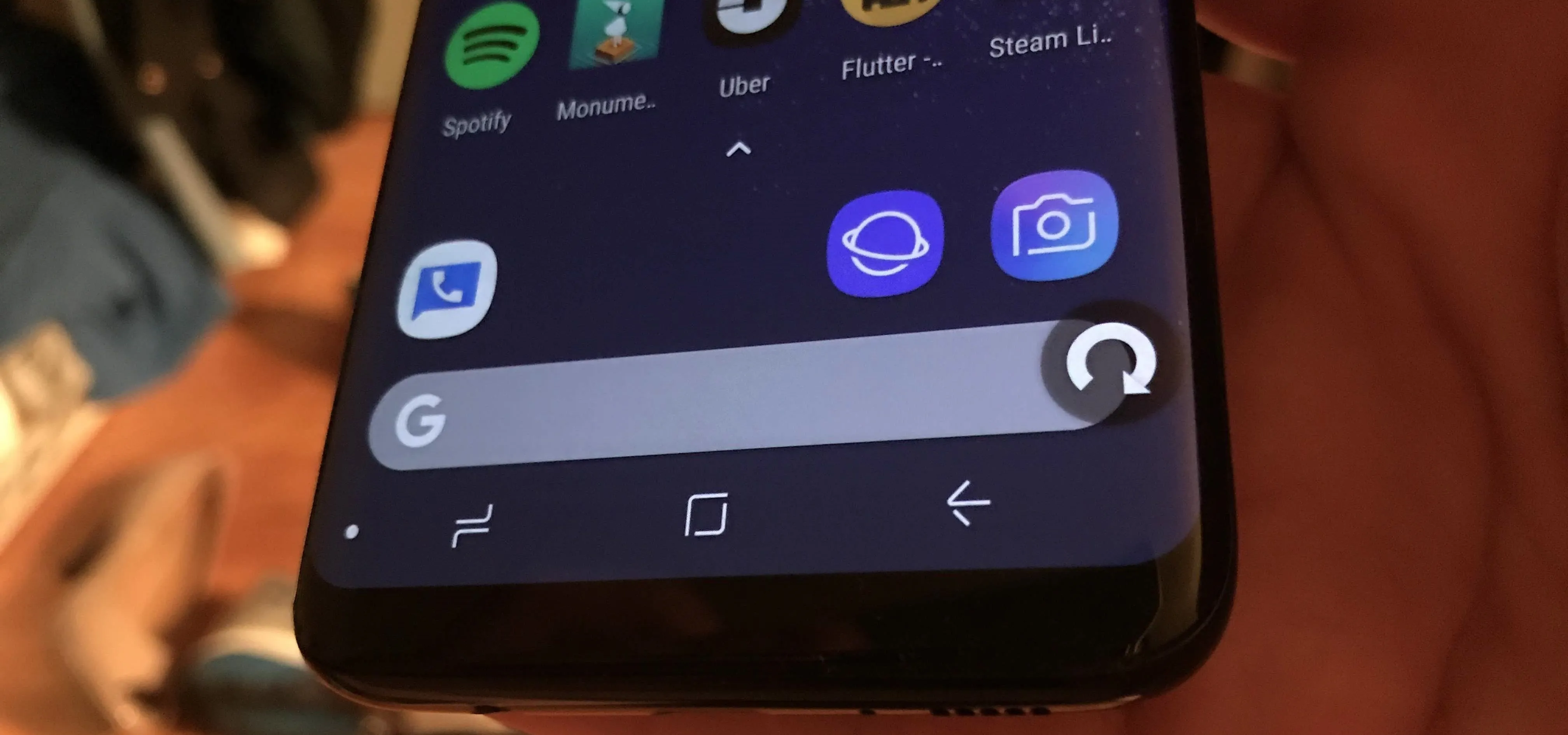 Close-up of a smartphone screen showcasing various app icons and a search bar.