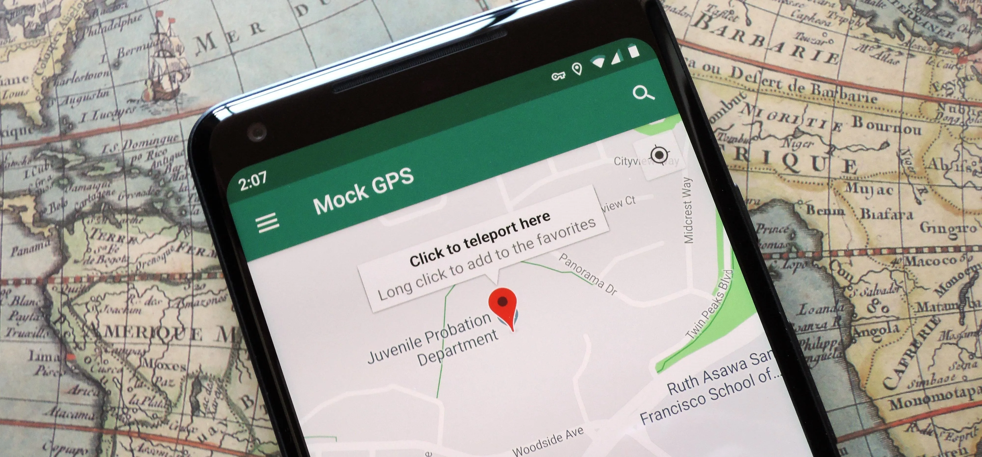 Mobile GPS location marker on a smartphone displayed over a vintage world map.