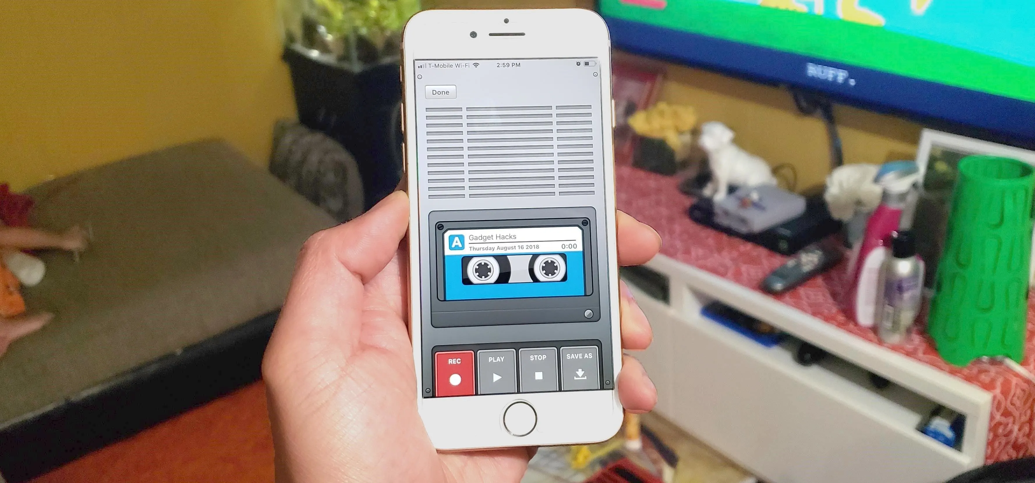A person holding a smartphone displaying a vintage cassette player interface.