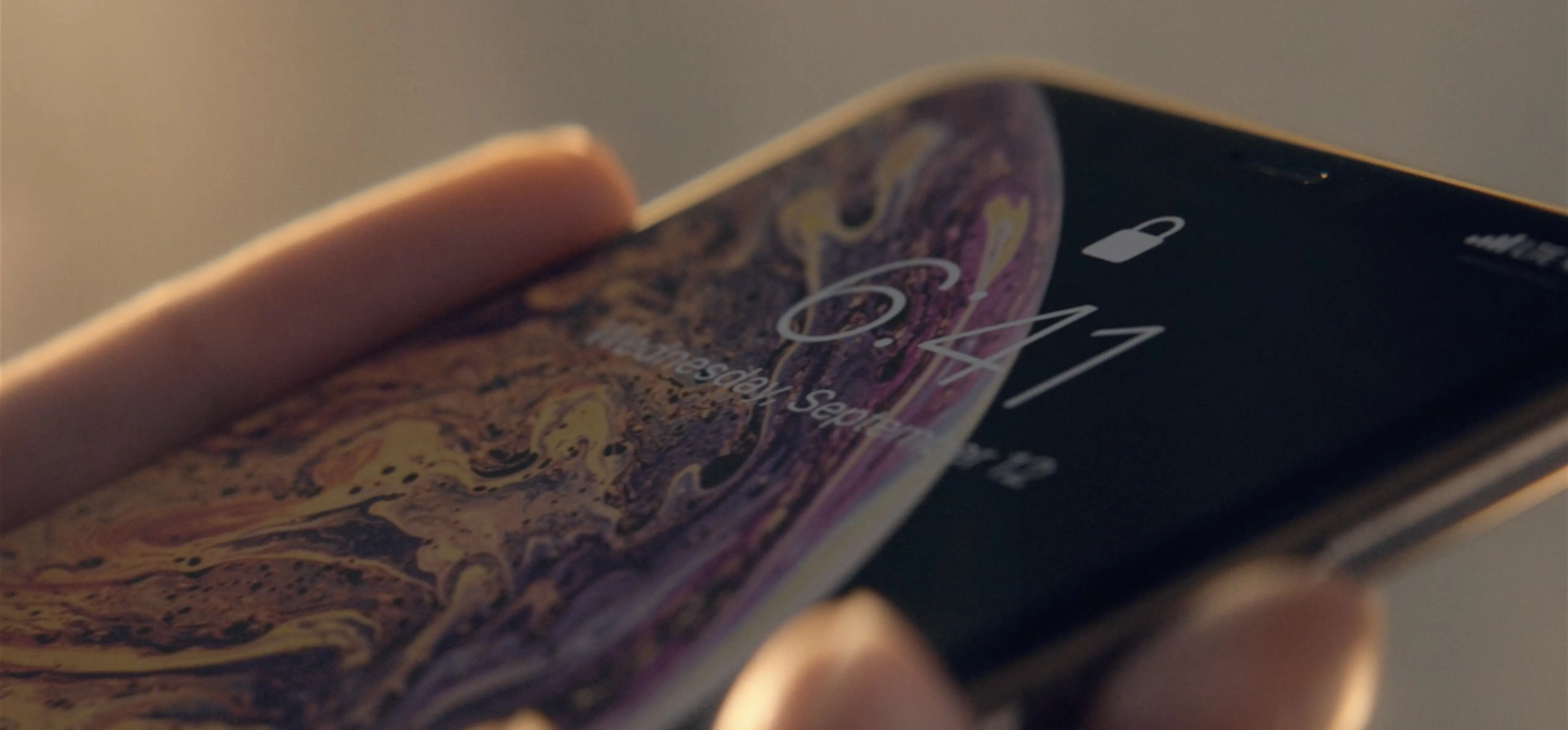 Close-up of a person holding a smartphone displaying the time.