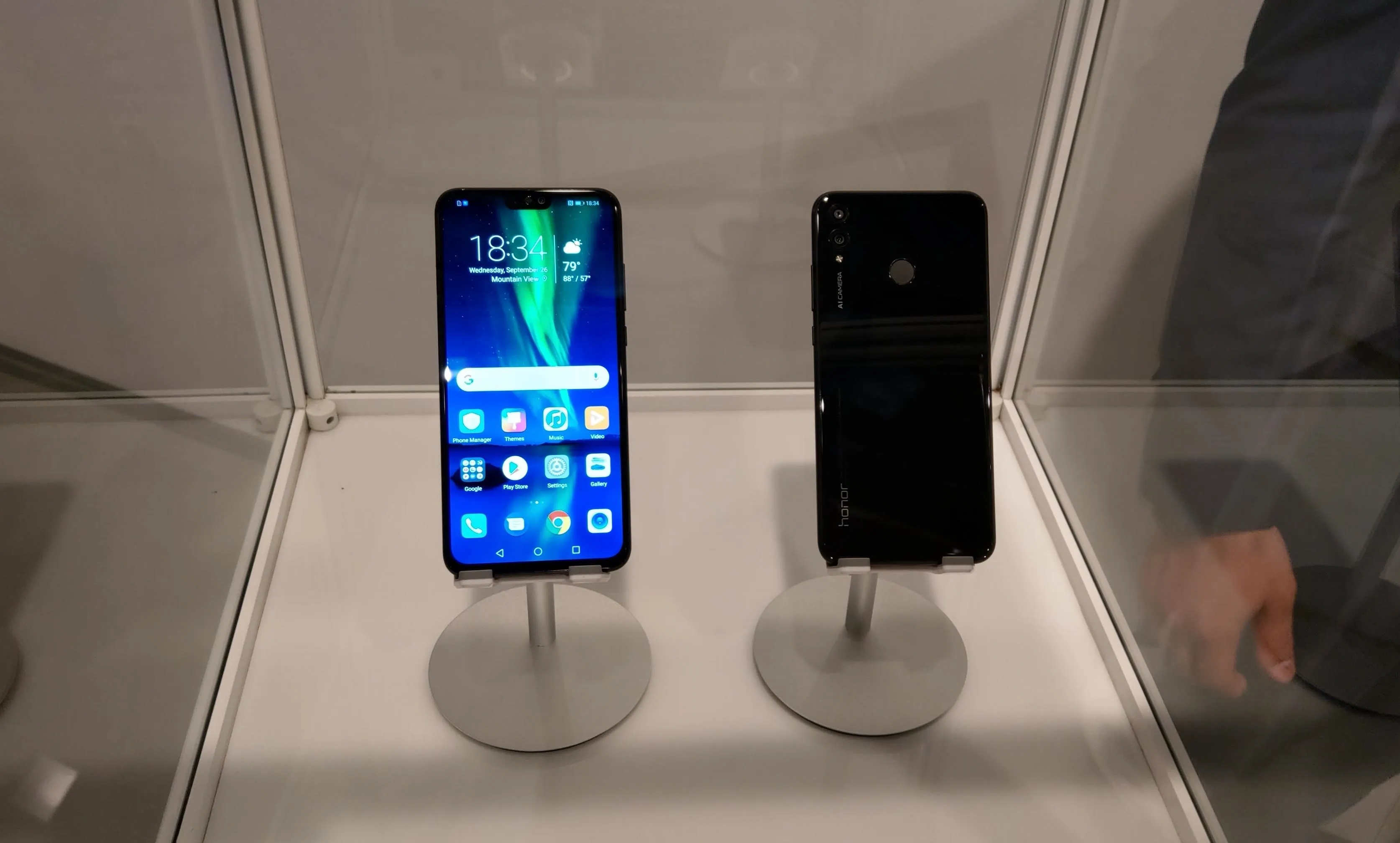 Smartphones displayed on stands in a showcase.