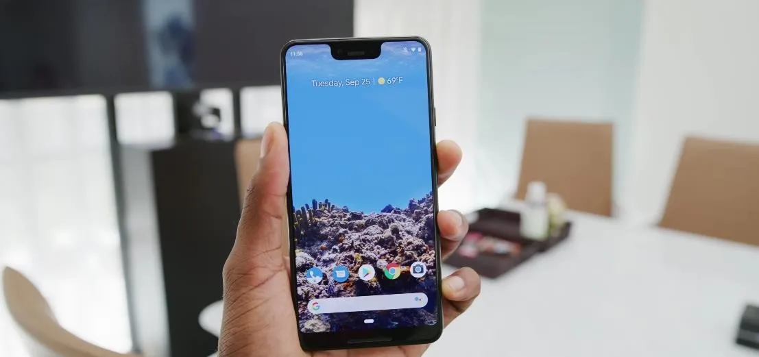 Smartphone displaying a scenic wallpaper in a modern office setting.