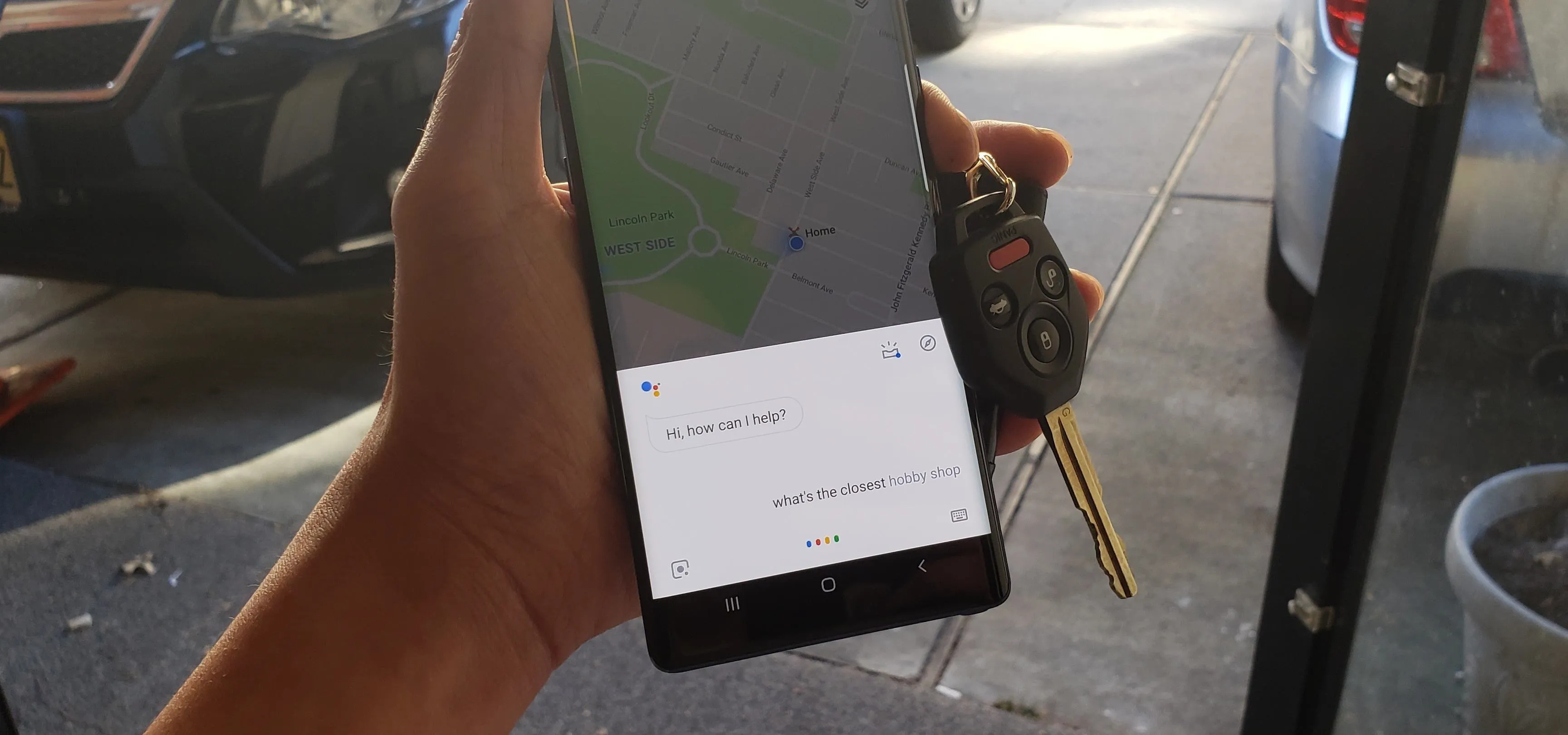 Smartphone displaying a map with car keys in hand.
