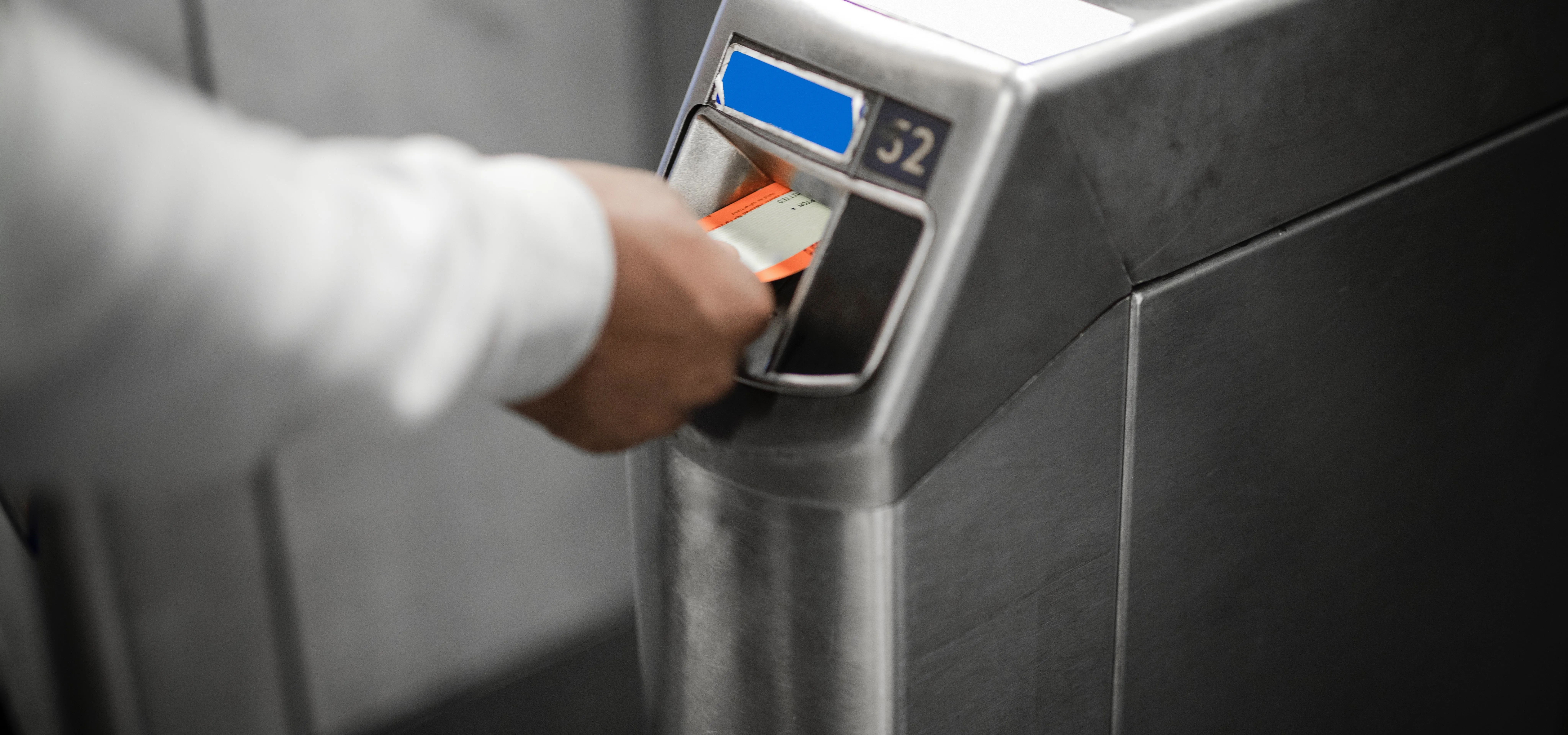 Person using a card reader at a ticket machine.
