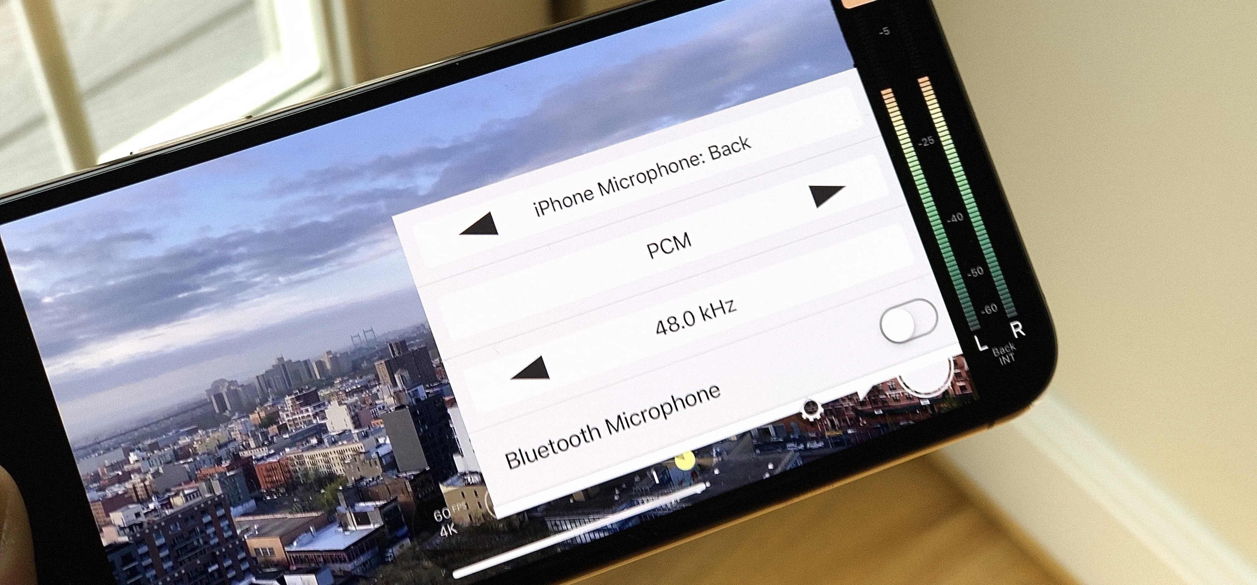 Mobile phone displaying Bluetooth settings and city skyline.