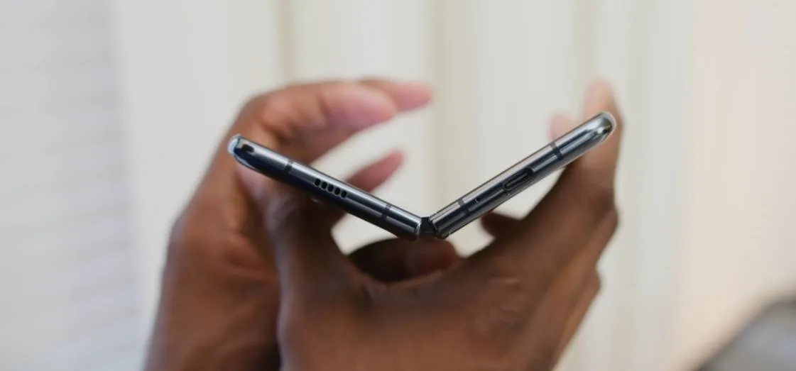 Hands holding a folded smartphone.