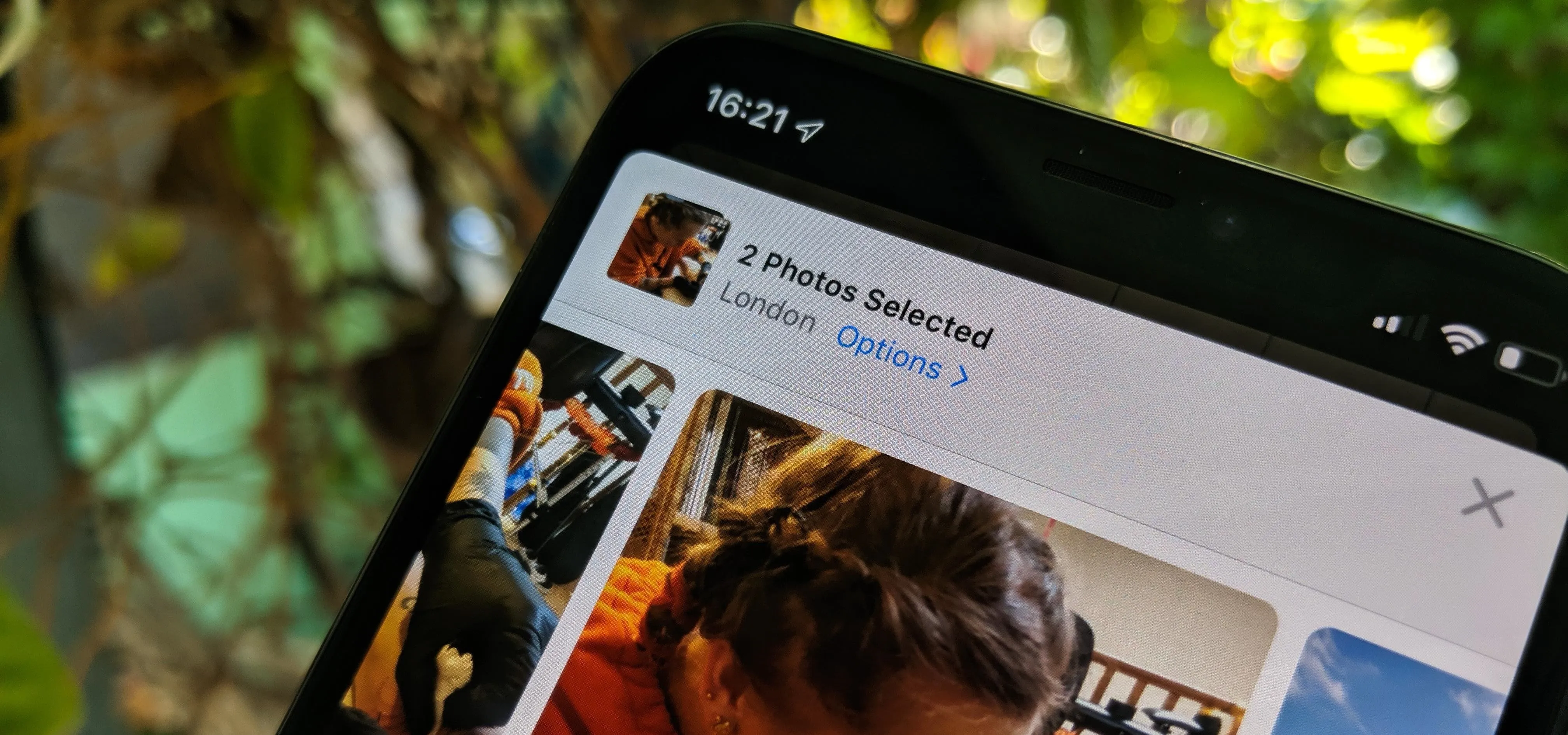 Phone screen displaying a photo selection interface with two photos chosen.