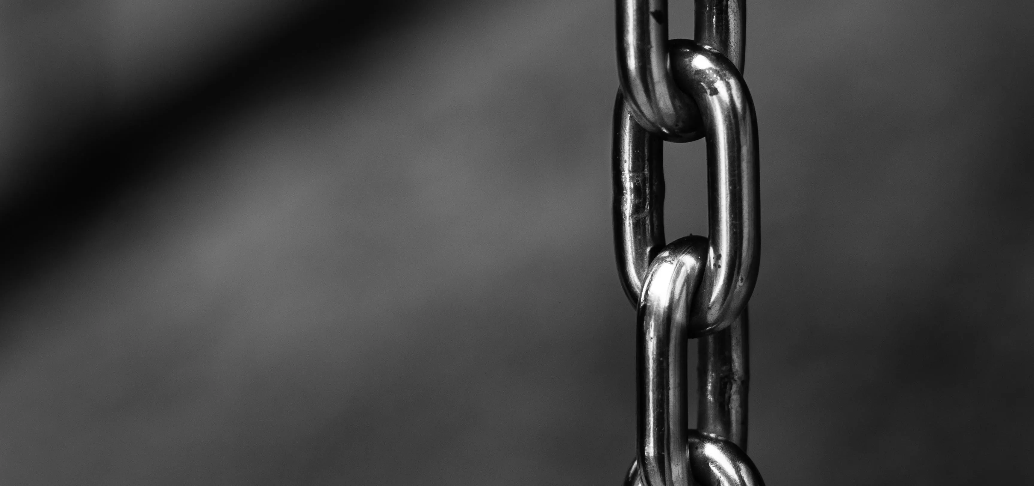 Close-up of metallic chain links on a dark background.
