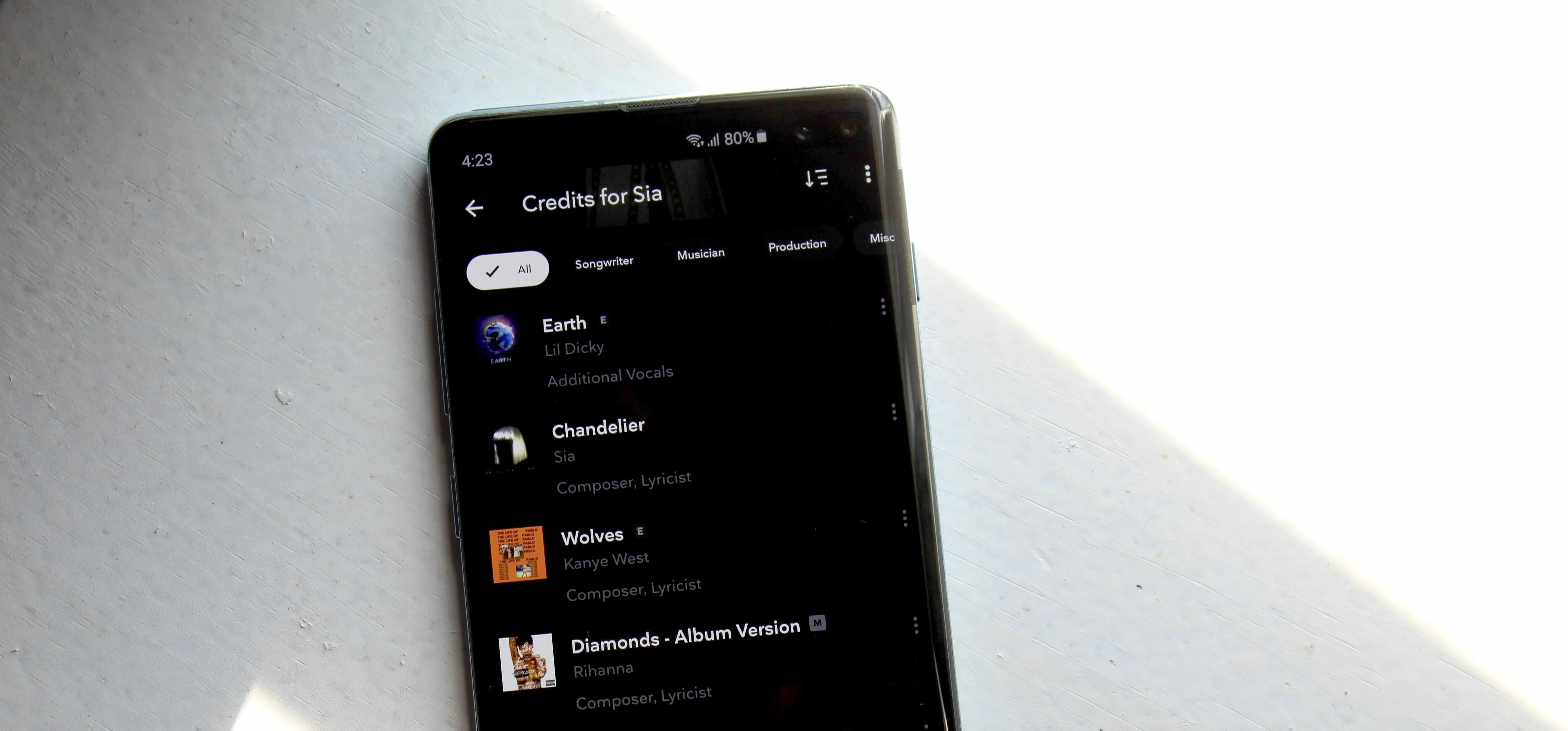 Image of a smartphone displaying a music streaming app with a list of playlists.