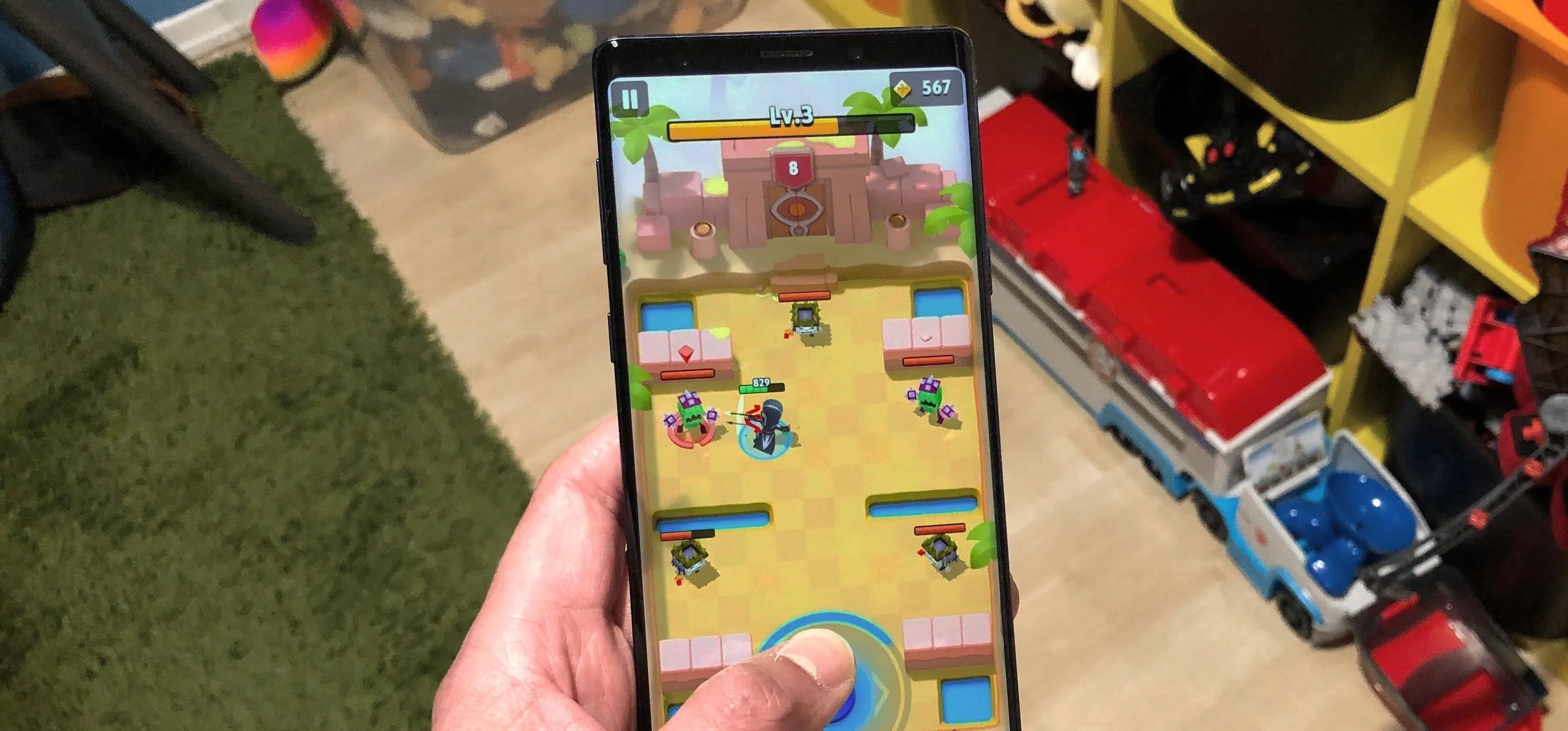 Person playing a mobile game on a smartphone in a casual environment.