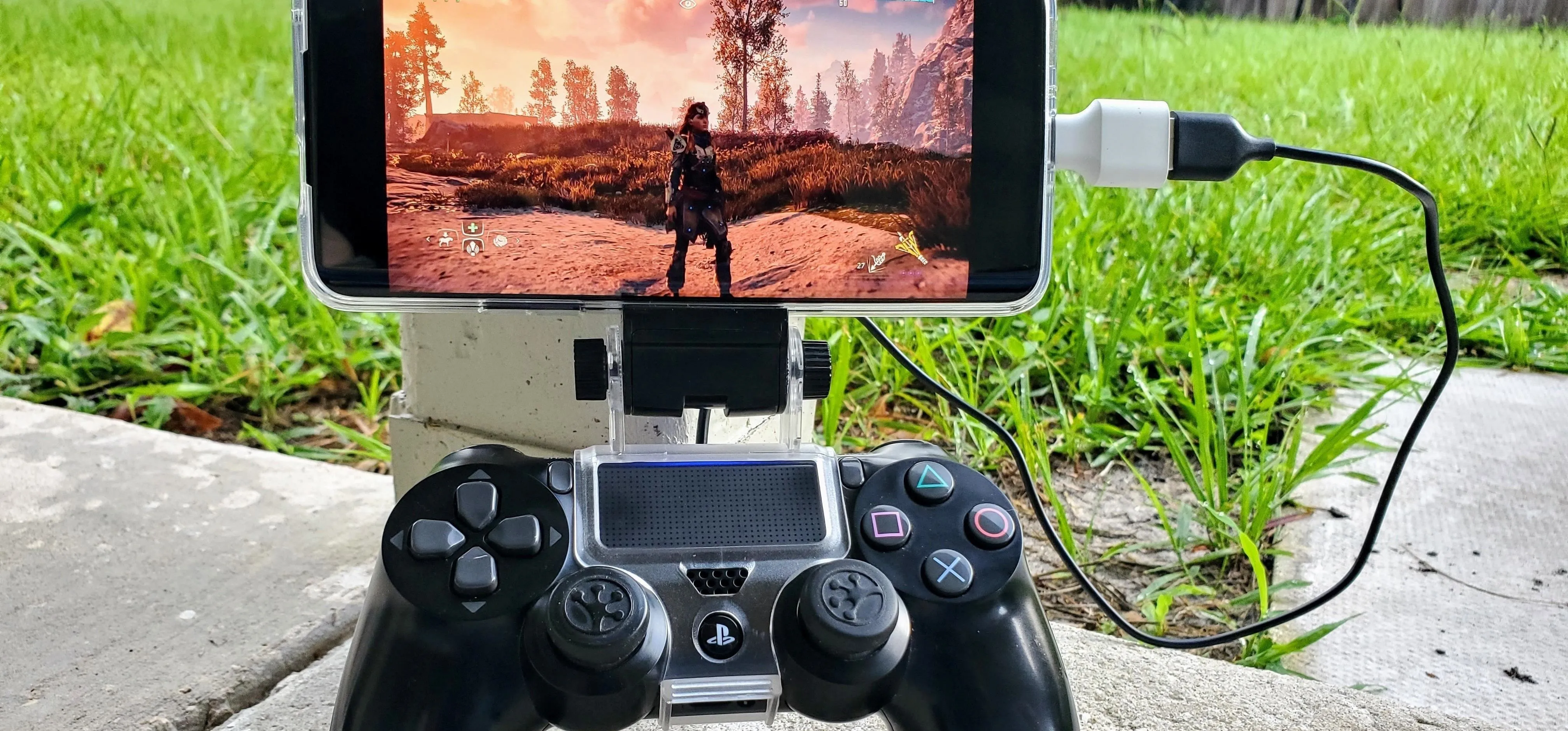 Mobile gaming setup showcasing a controller connected to a smartphone displaying a gaming scene.