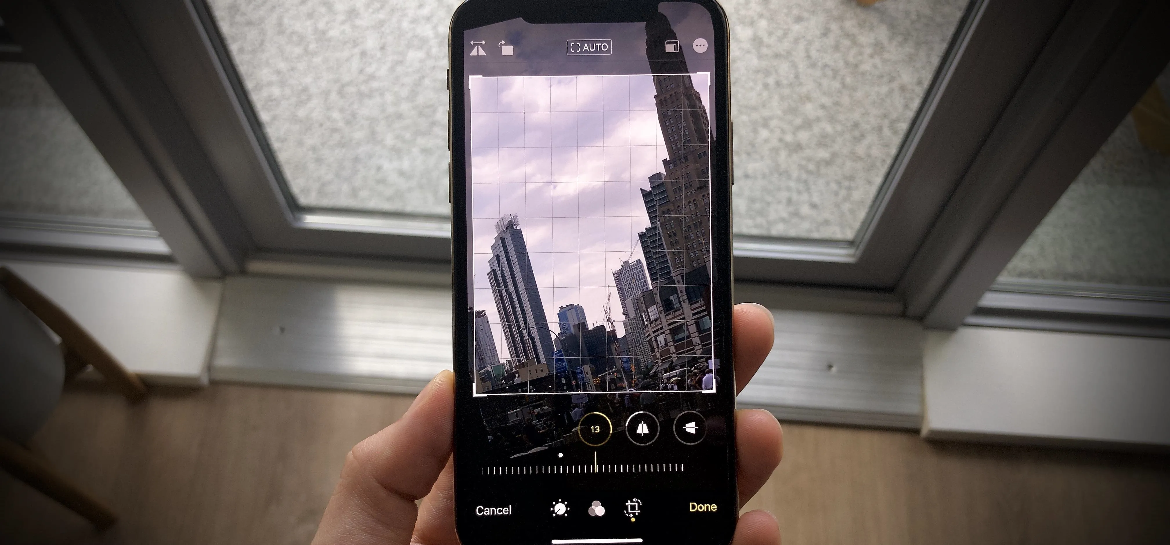 Hand holding a smartphone displaying a photo of a cityscape.