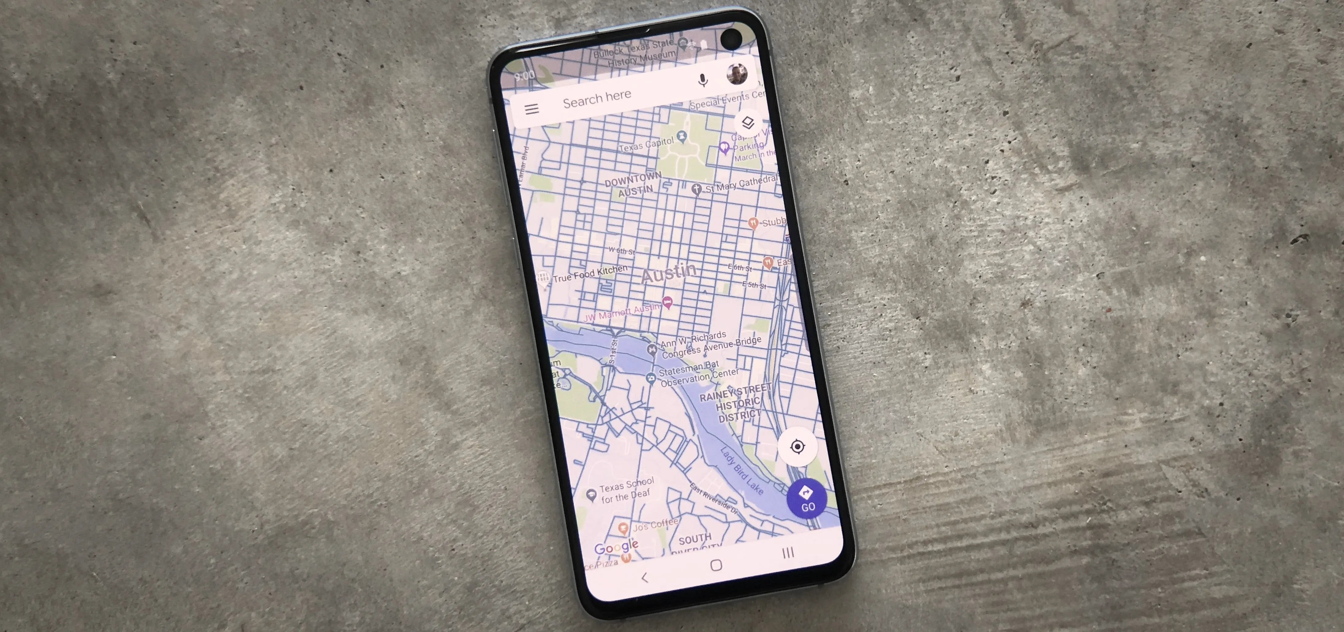 Mobile phone displaying a map on a concrete surface.