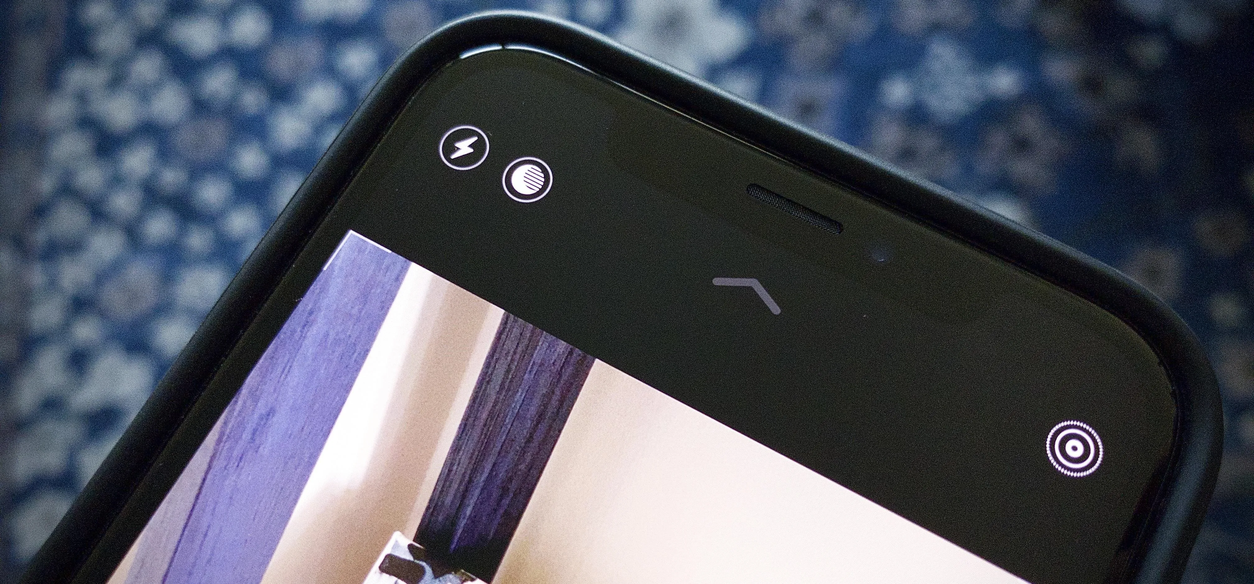 Close-up of a smartphone camera interface with icons for flash and camera settings.