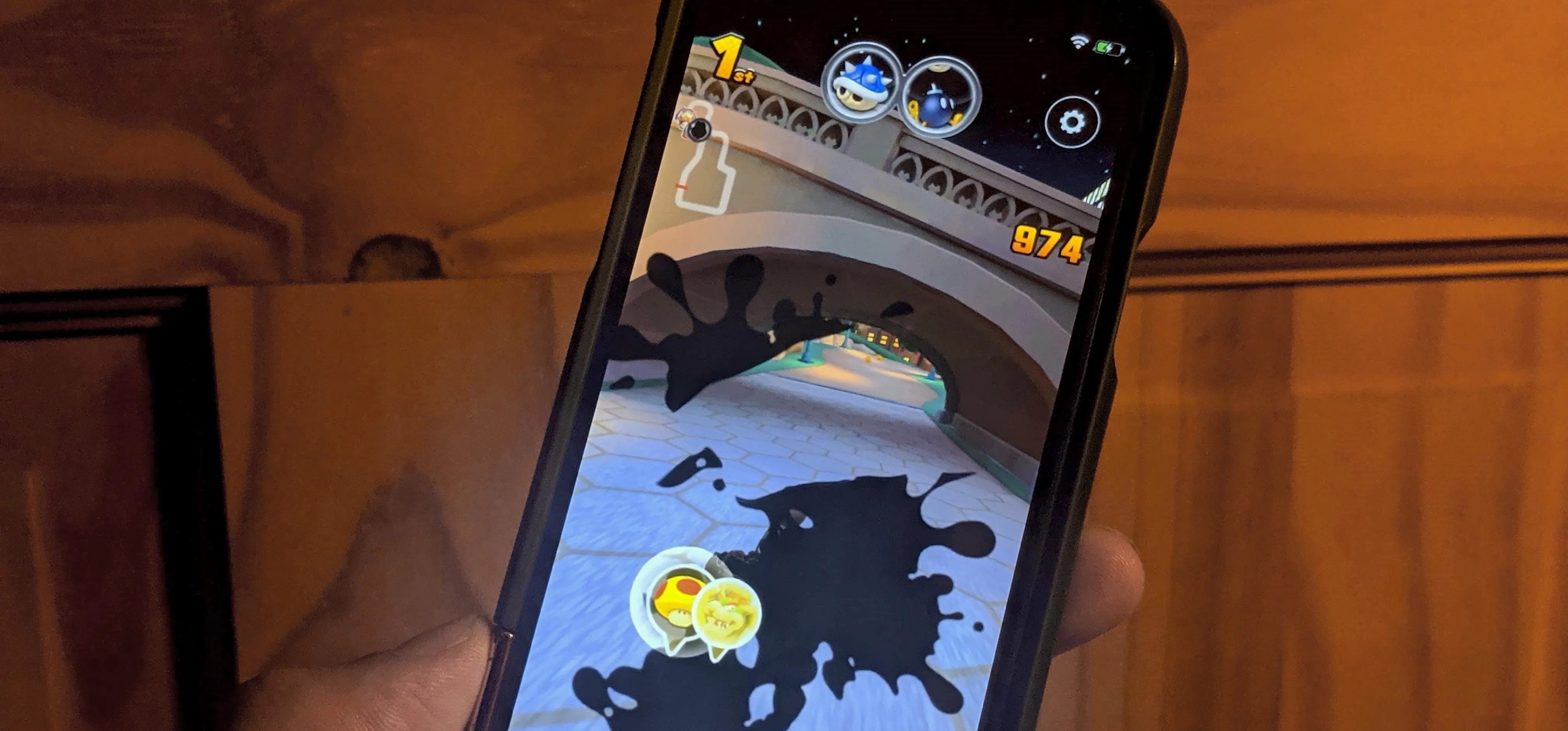 Mobile phone displaying a gaming app interface with a character navigating through a colorful landscape.