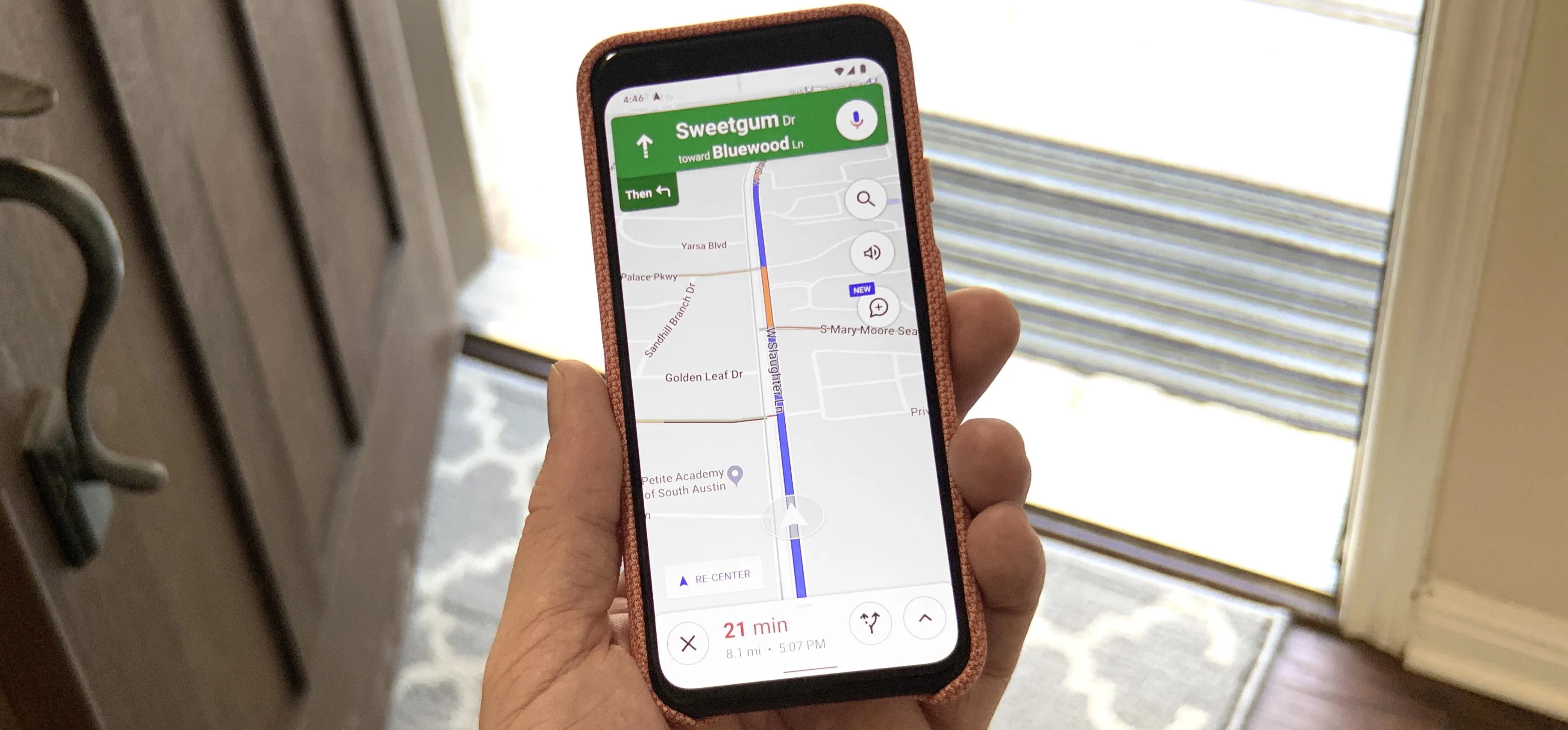 Smartphone displaying a navigation app at a doorway.