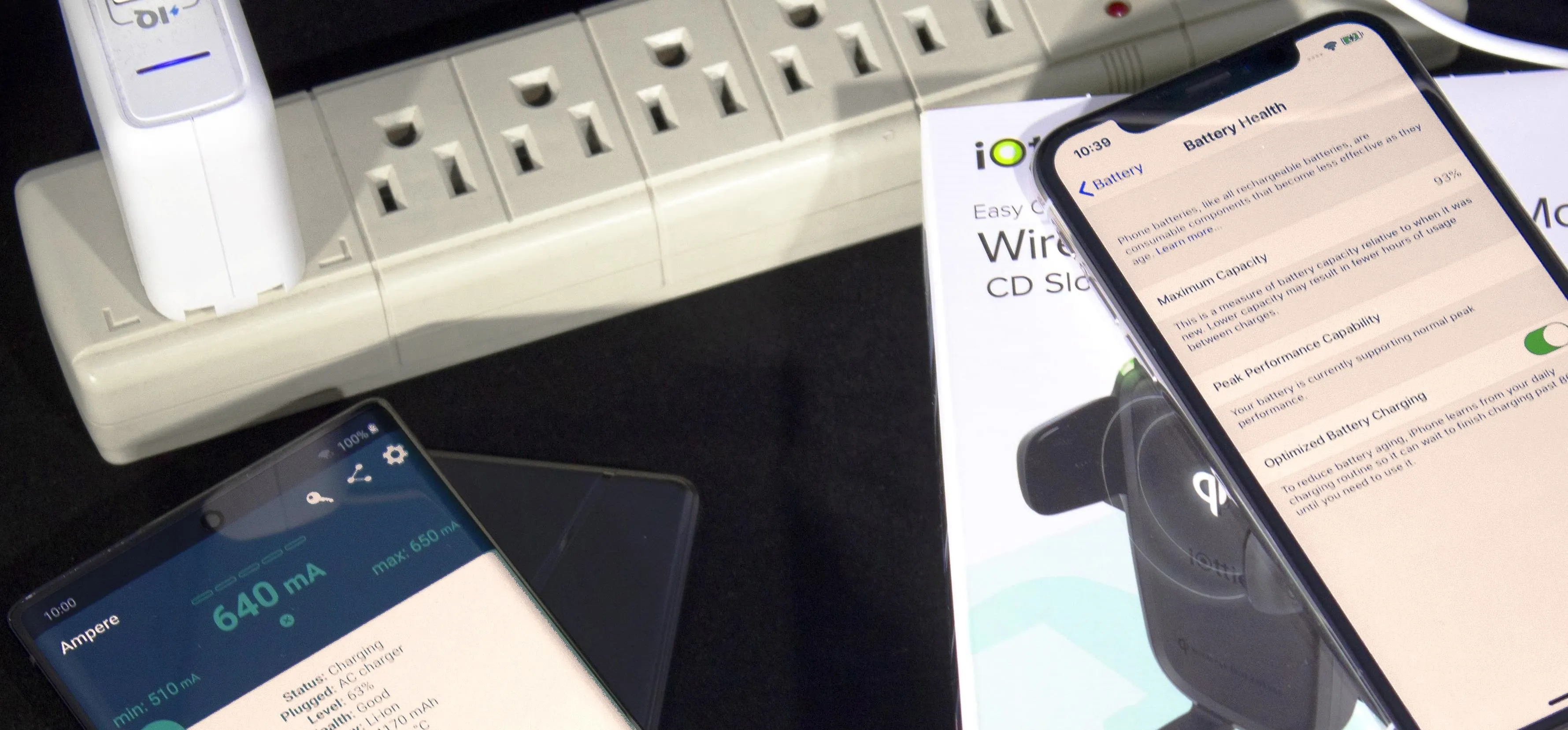 Smartphones connected to a power strip with a product manual displayed.
