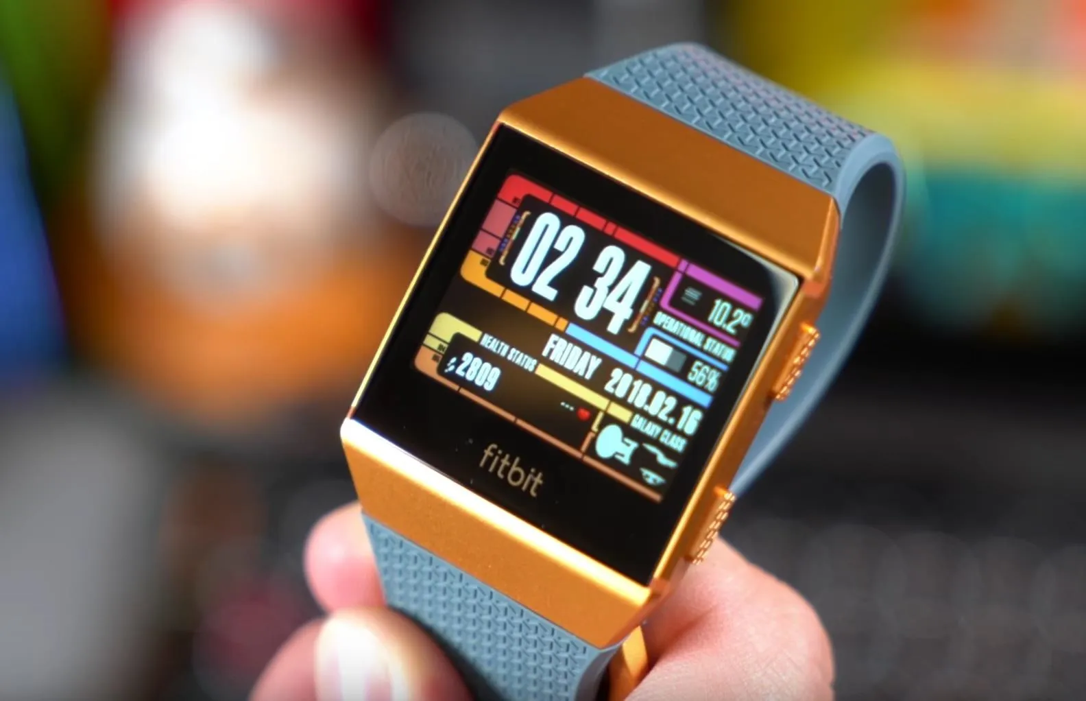Fitbit smartwatch displaying fitness metrics and time.