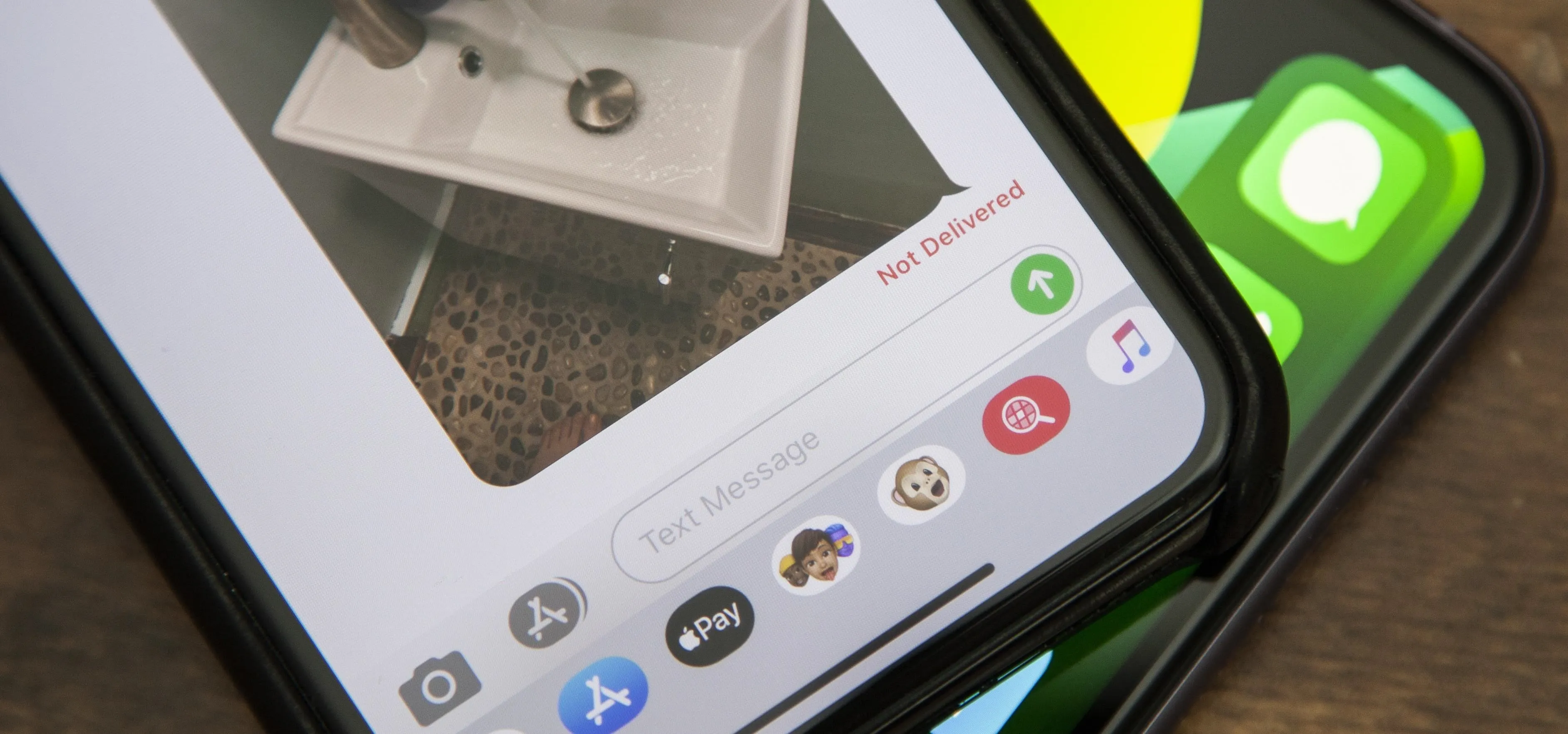 Mobile phone displaying a messaging app with an image of a sink and faucet.