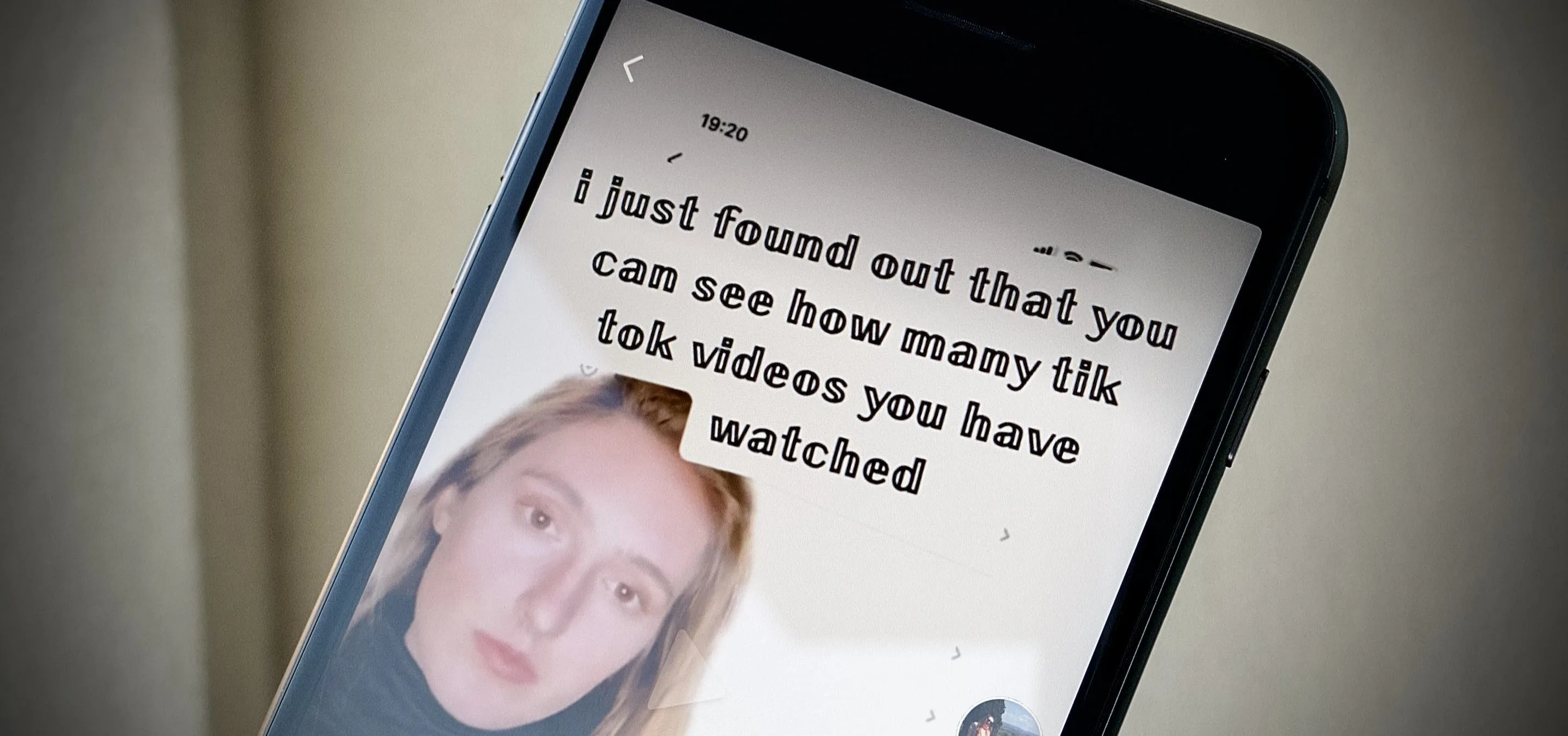 A person looking at a phone screen displaying TikTok video statistics.