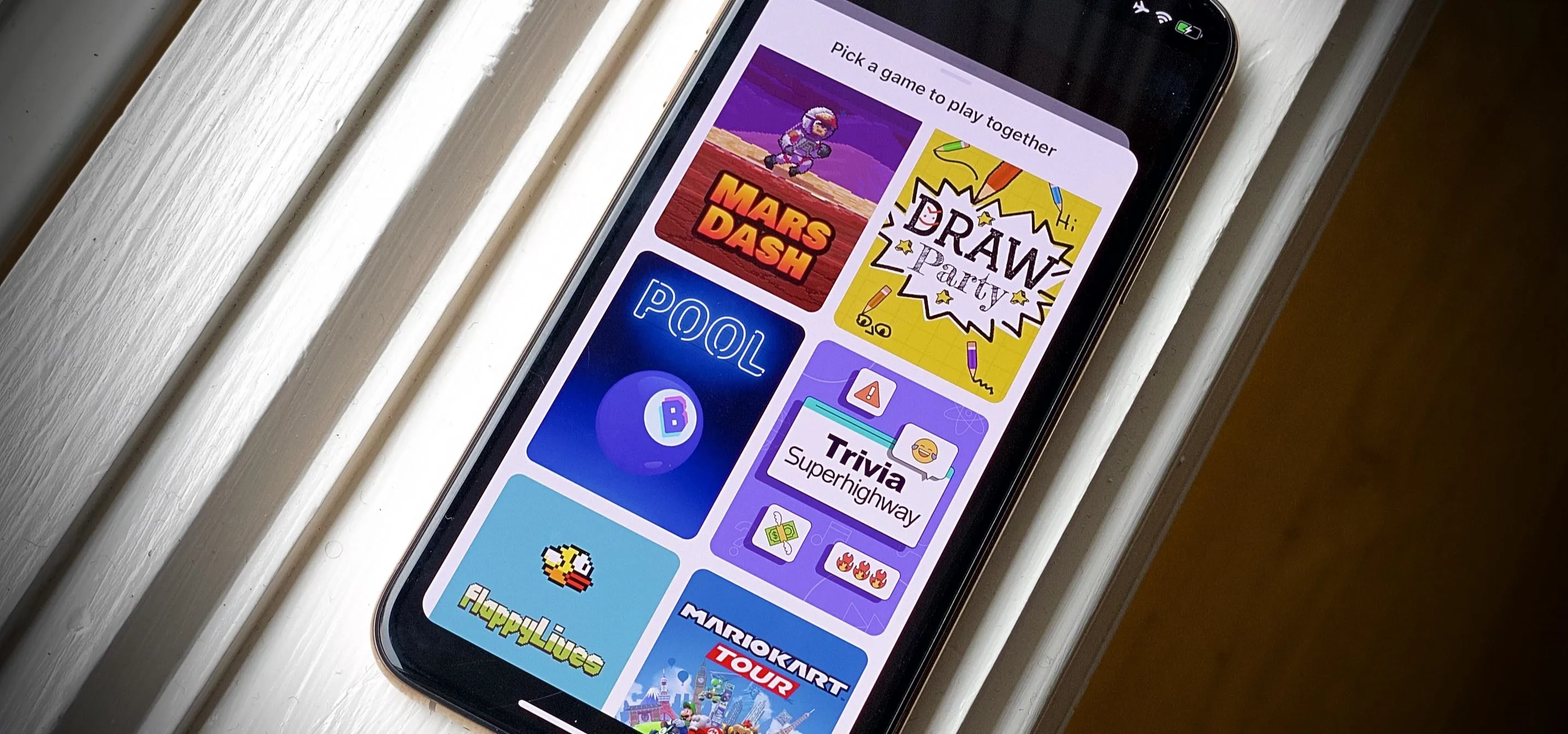 Smartphone displaying various game applications on screen.