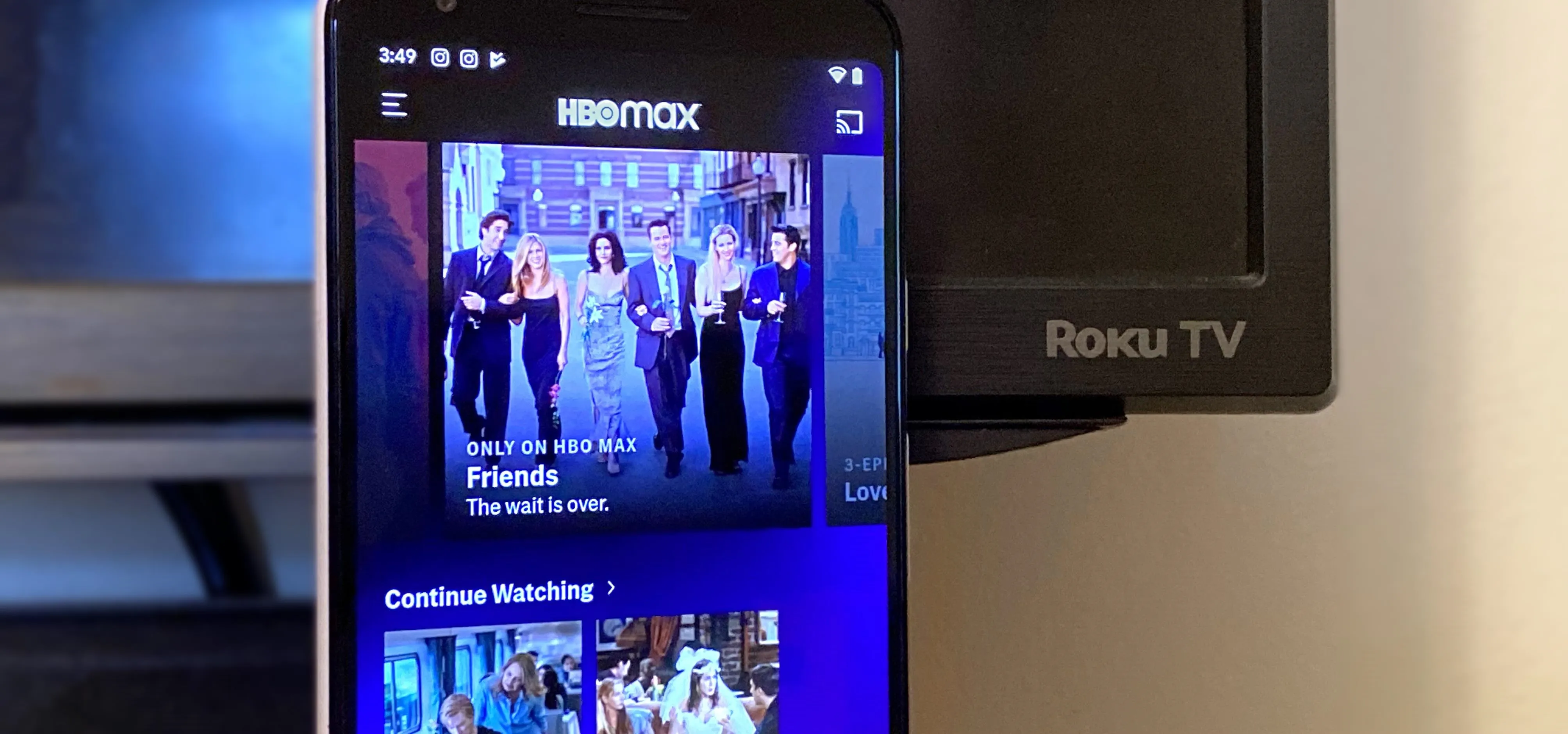 Smartphone displaying HBO Max app with the Friends series highlighted next to a Roku TV.