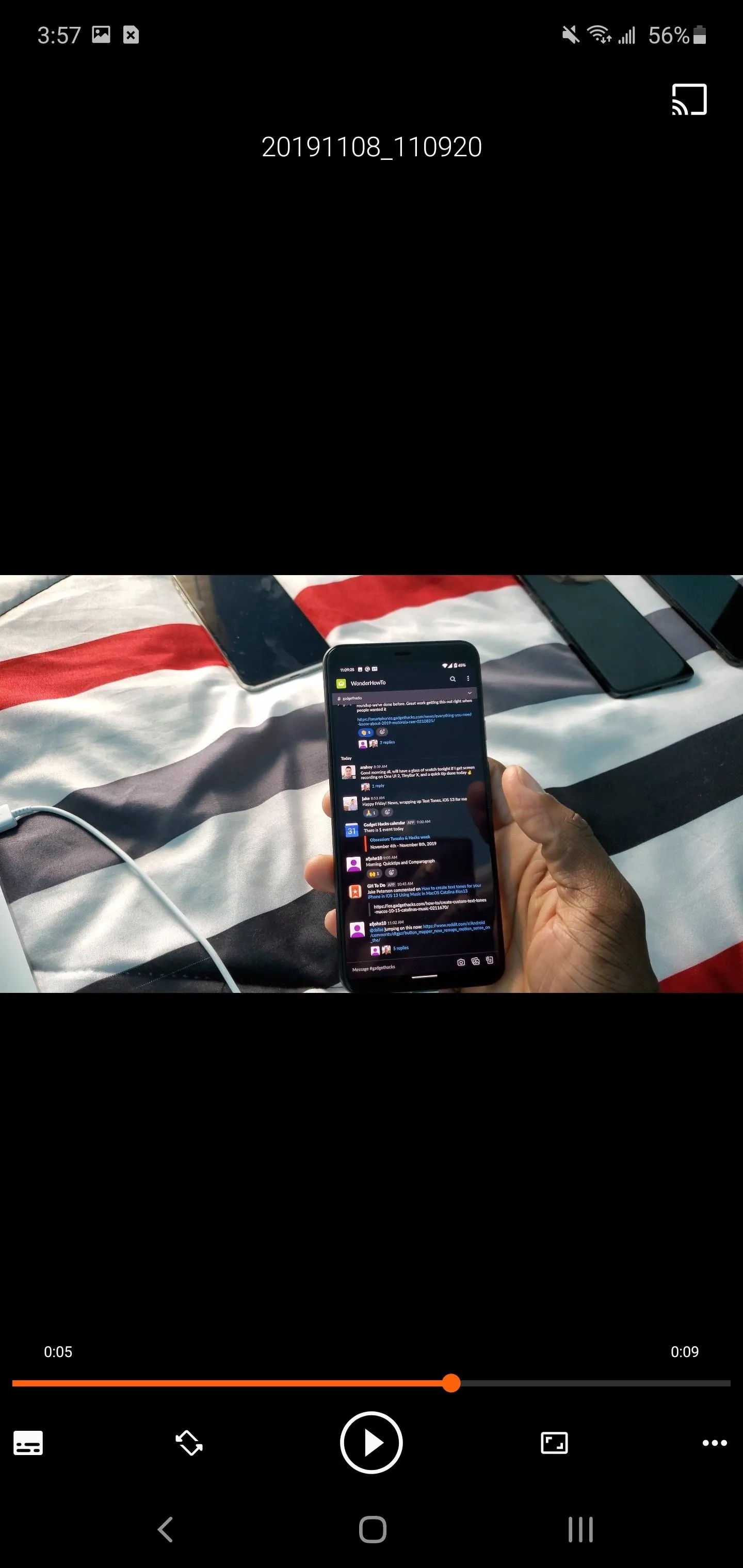 Smartphone held in hand displaying a messaging app on a patterned surface.