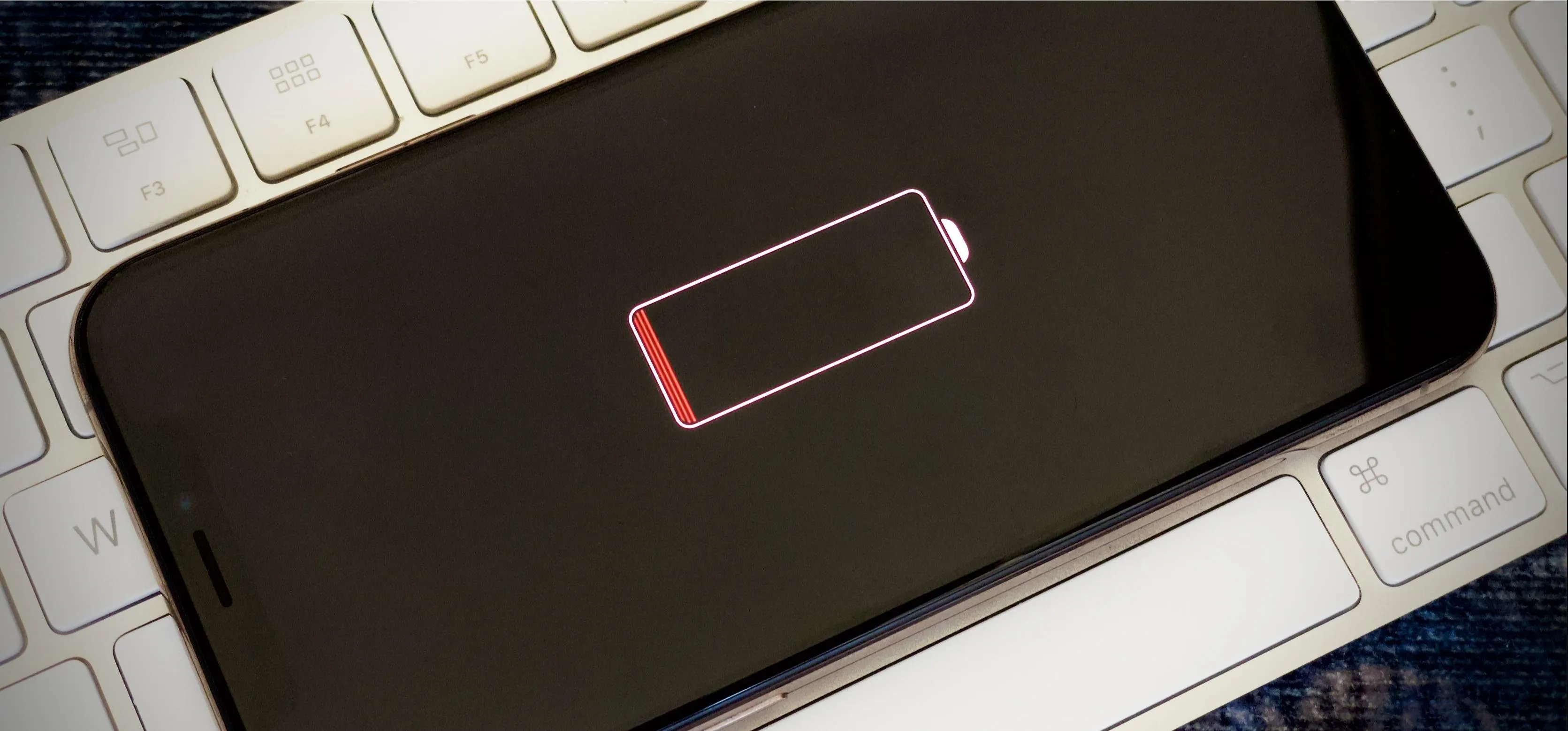 Mobile phone with low battery warning on screen.