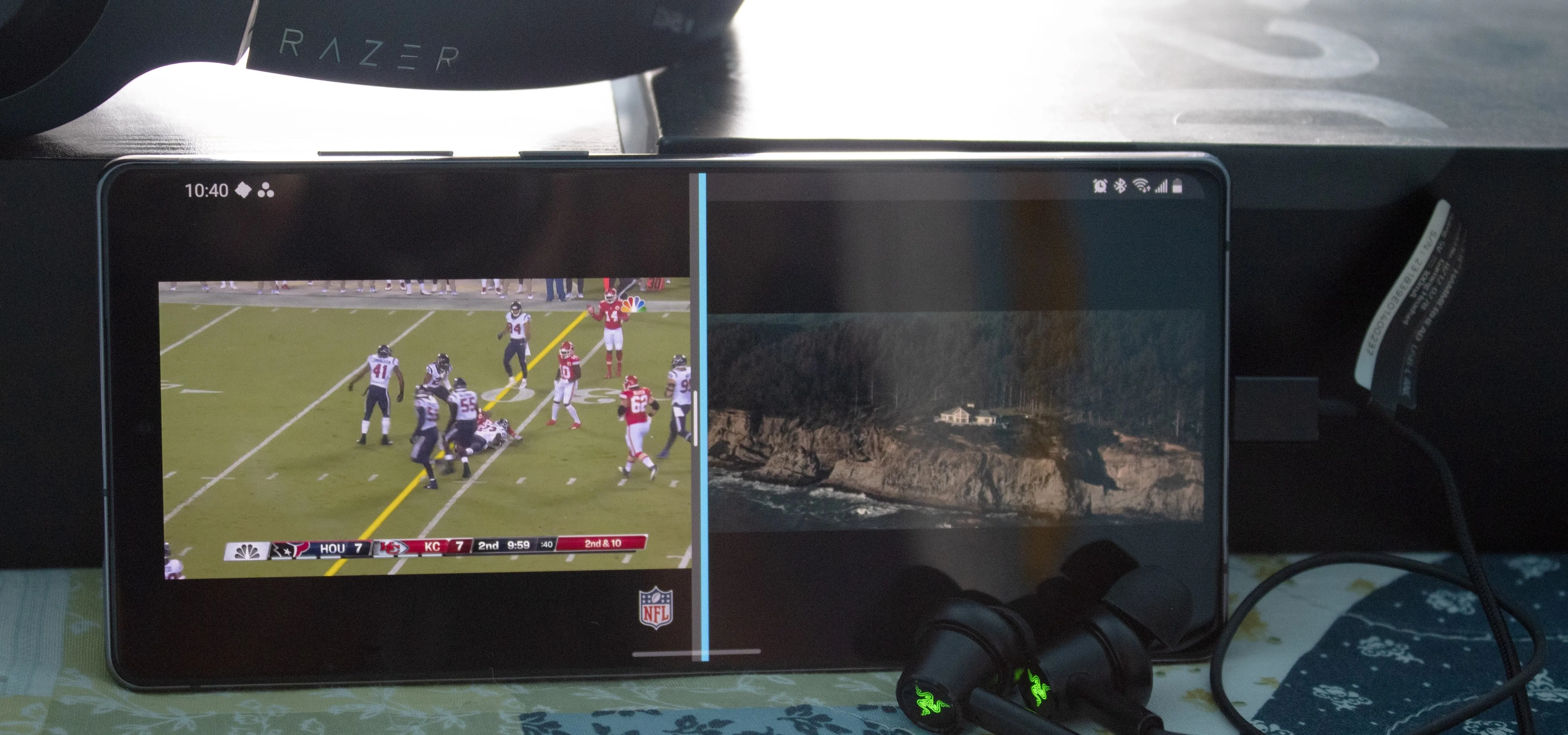 Dual screen setup displaying a sports game on one side and a scenic view on the other.
