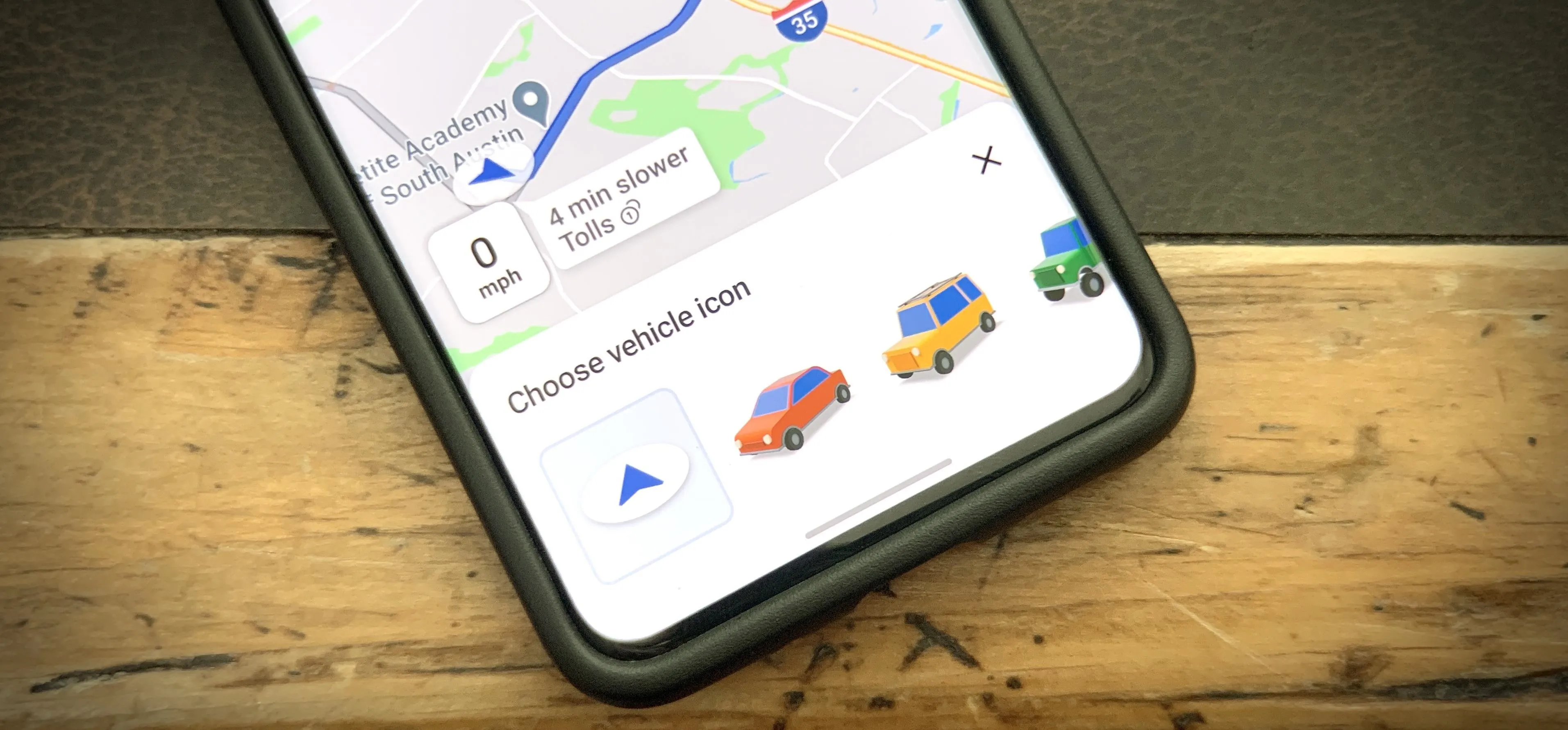 Mobile device displaying a map with driving directions and vehicle icons.