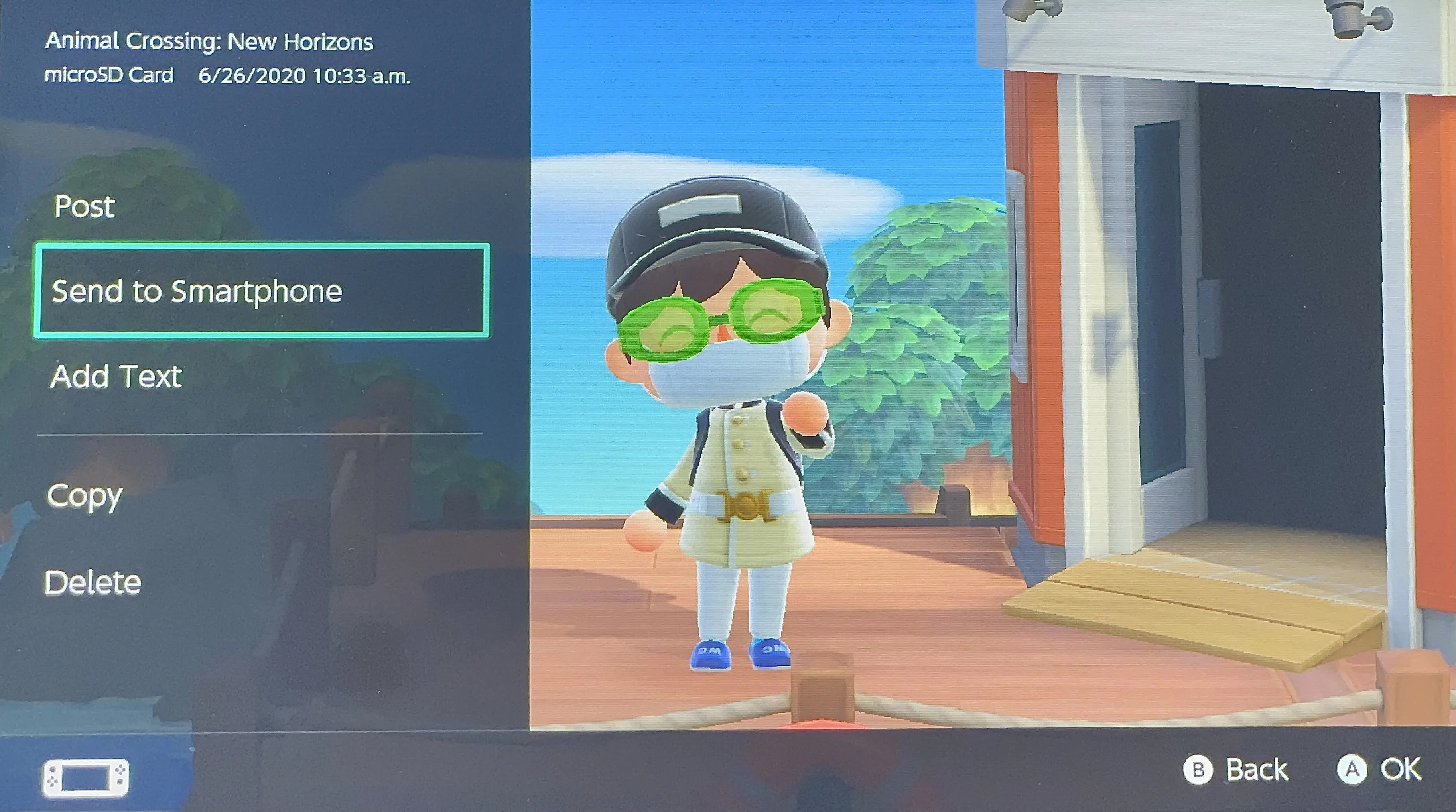 Player character in a virtual world with a hat and glasses, standing near a building.