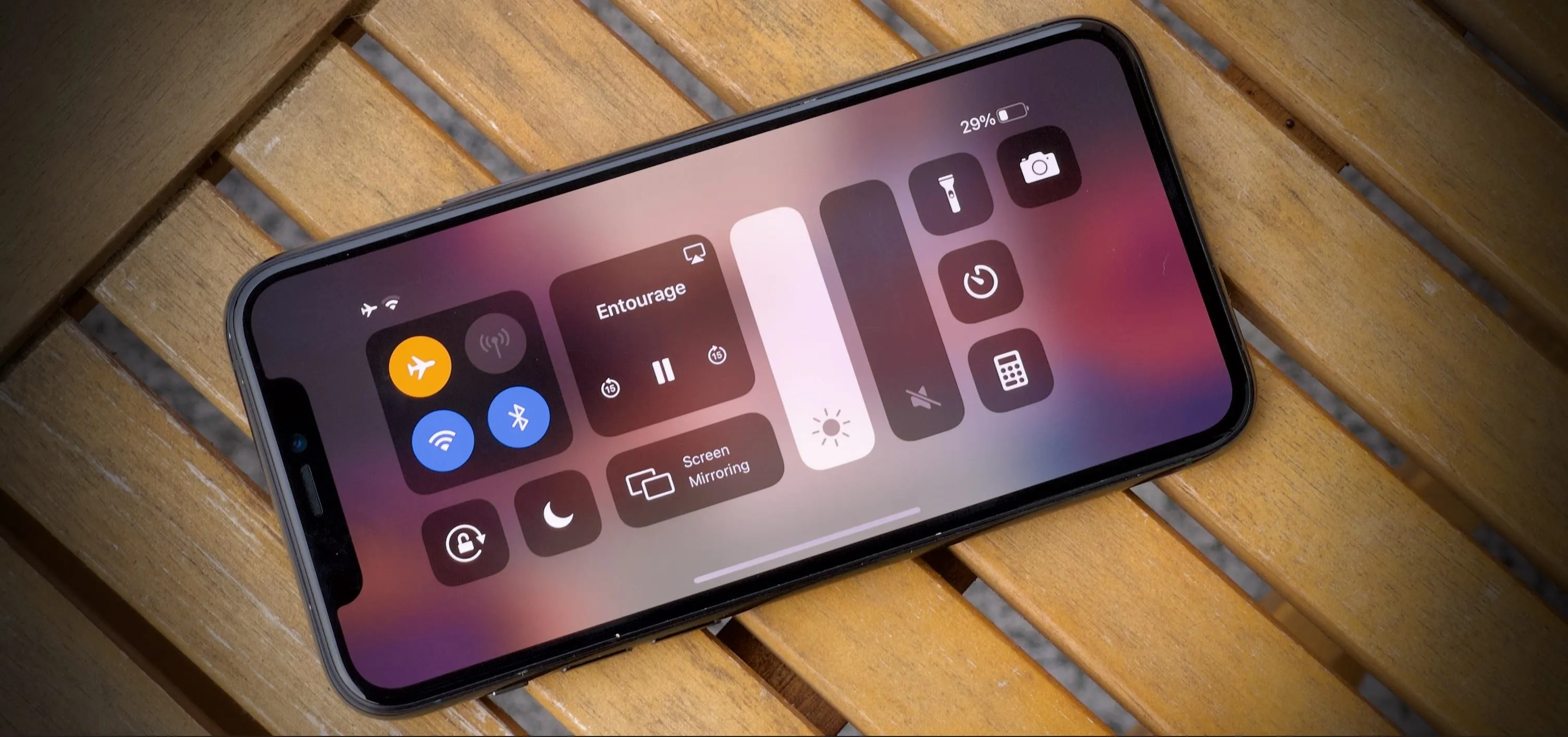 Smartphone displaying the control center interface on a wooden surface.
